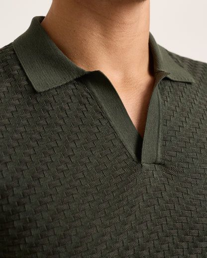 Close-up of green textured polo shirt on a plain background