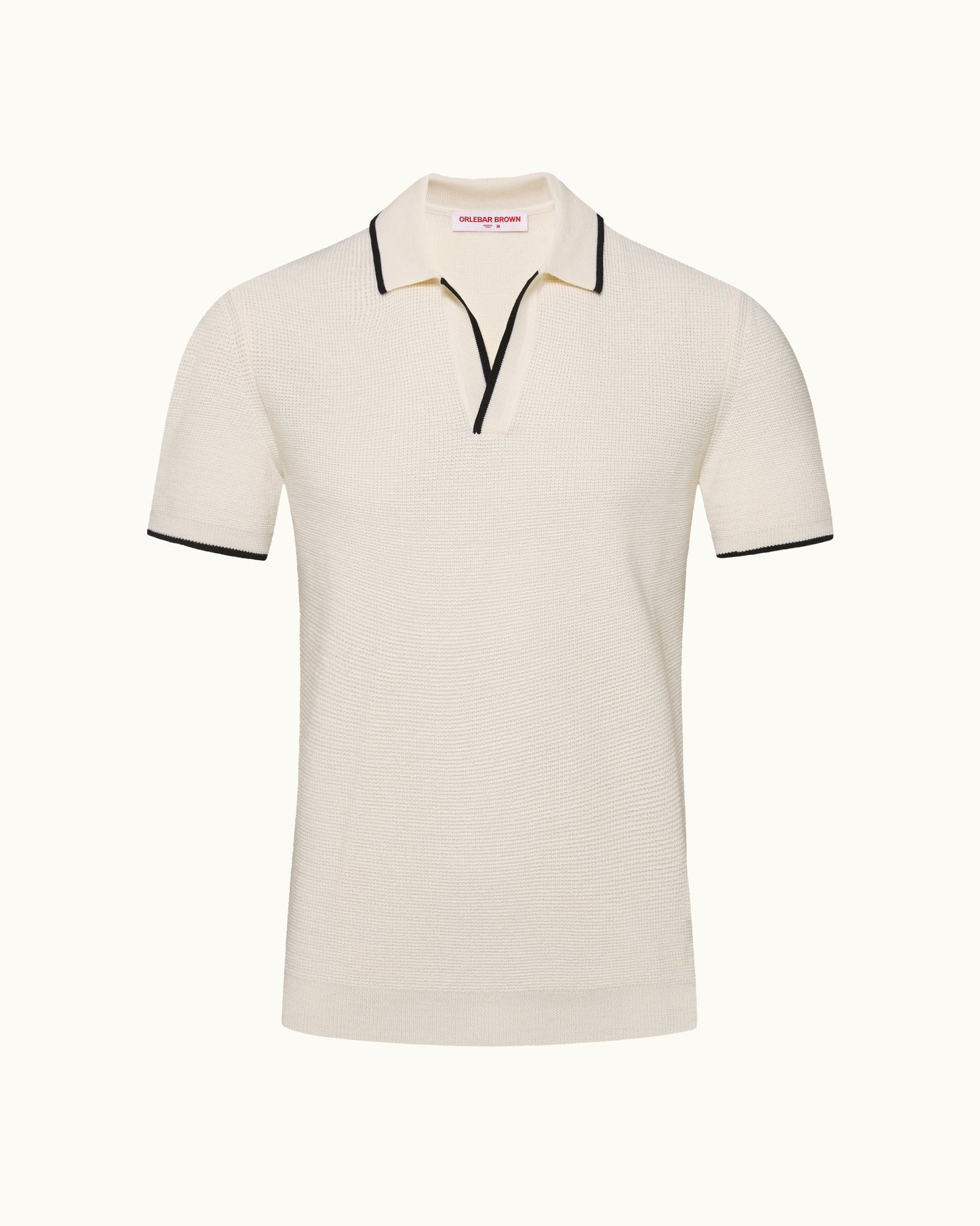 Beige polo shirt with black trim on a white background