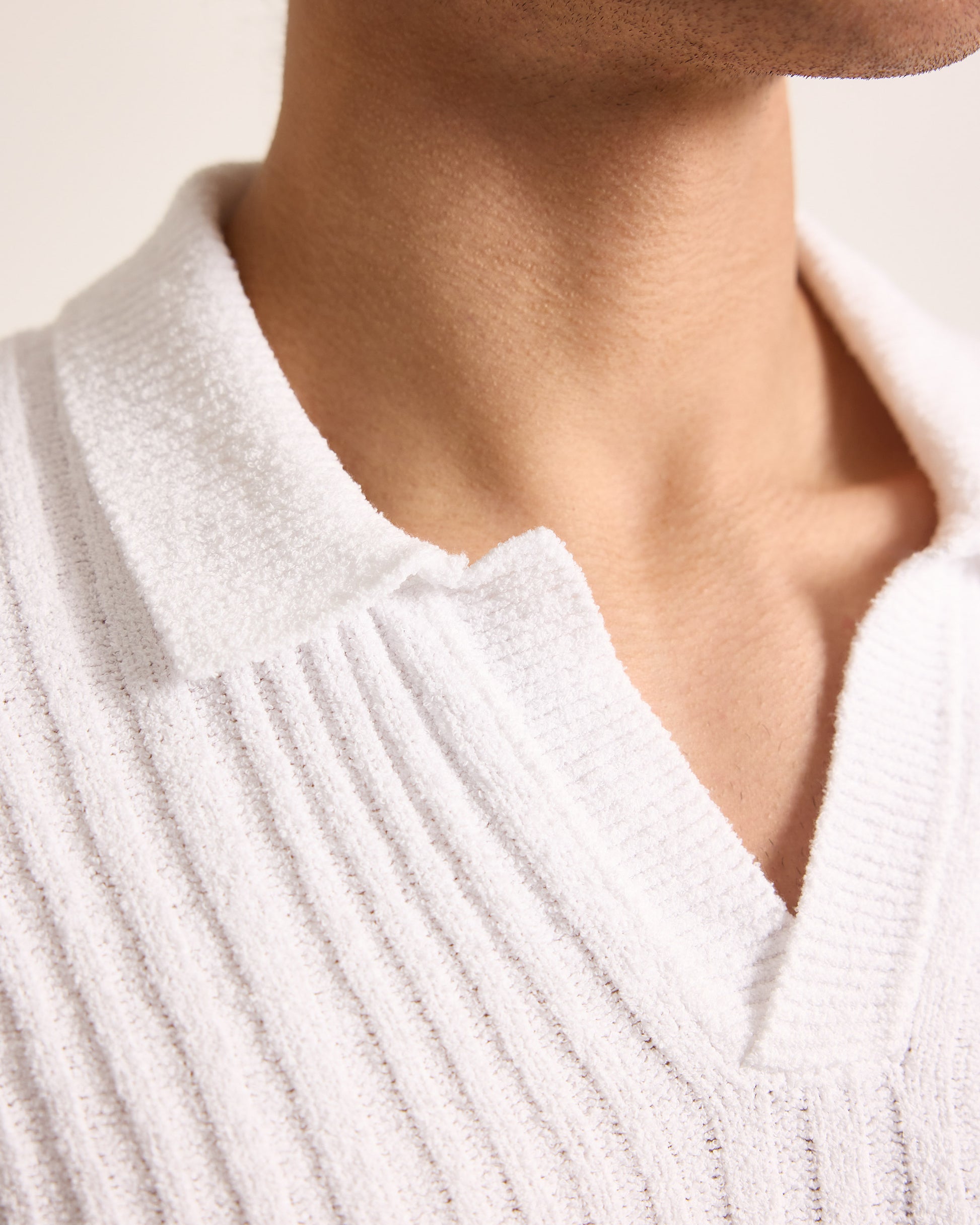 Close-up of a person wearing a white ribbed sweater