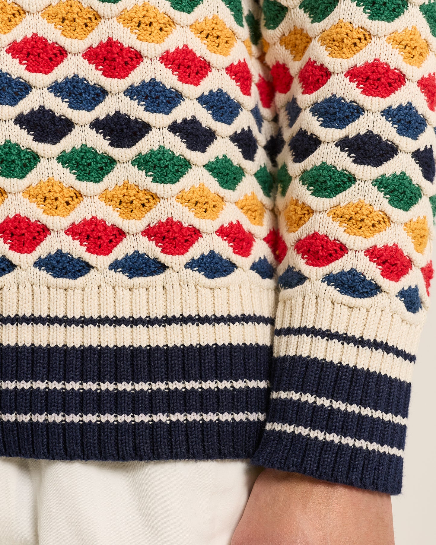Colorful patterned sweater with geometric design on a neutral background