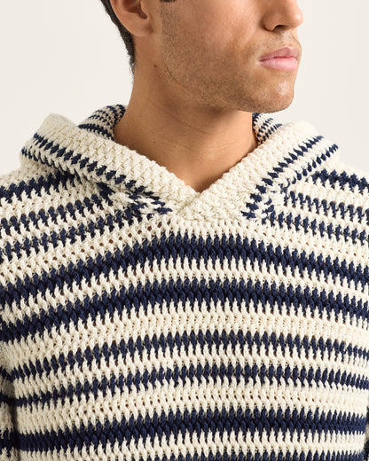 Close-up of a person wearing a navy and white striped sweater with a hood.
