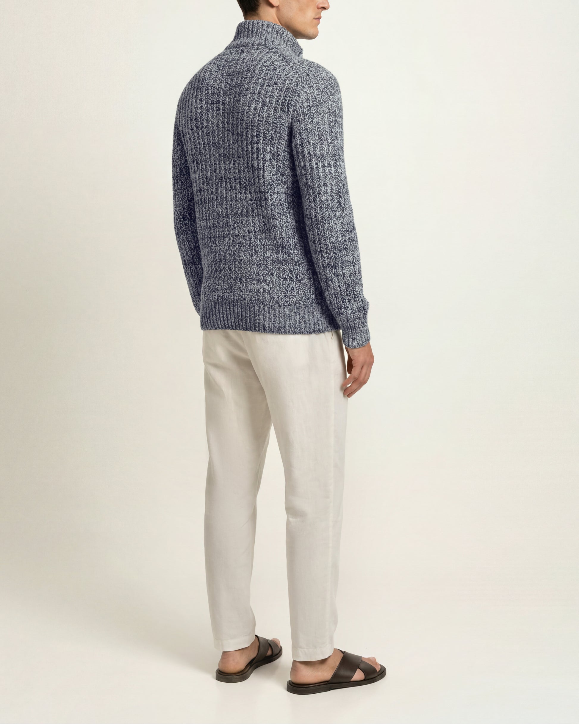 Side image of a model wearing crochet mix knitted top in white and navy with white trousers and sandals