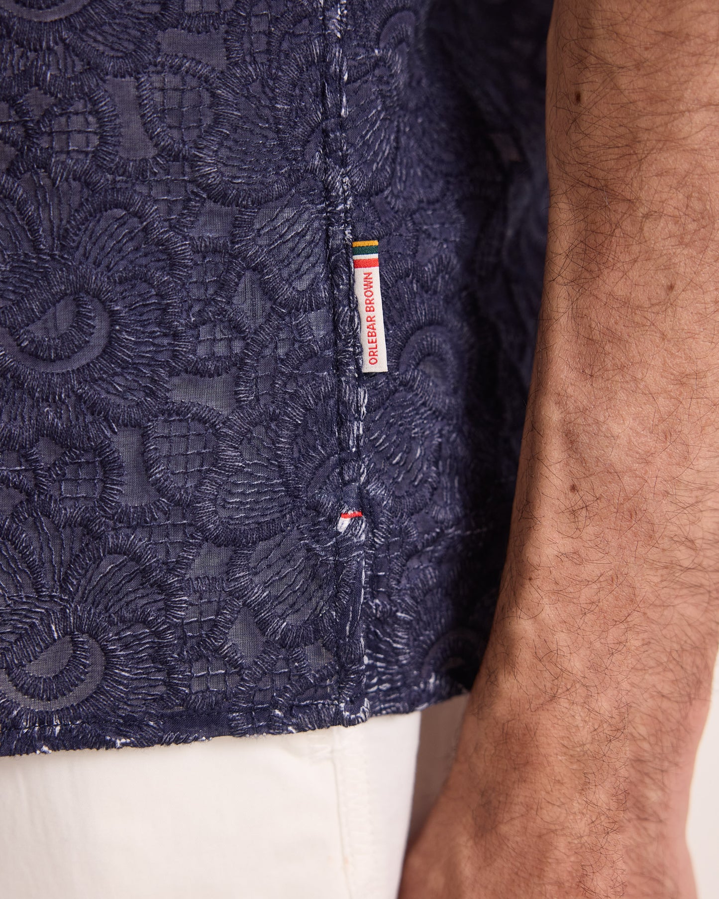 Closeup of navy embroidery shirt with branded detailing