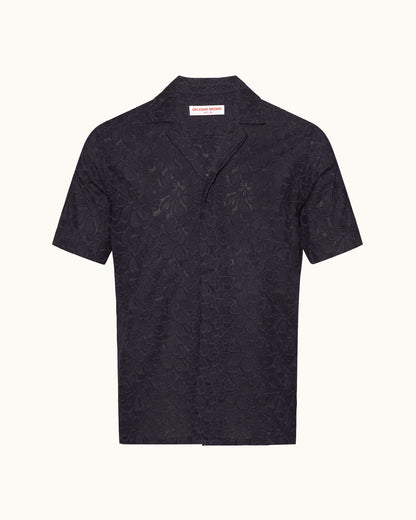 Short sleeve navy broderie anglaise shirt on a plain background