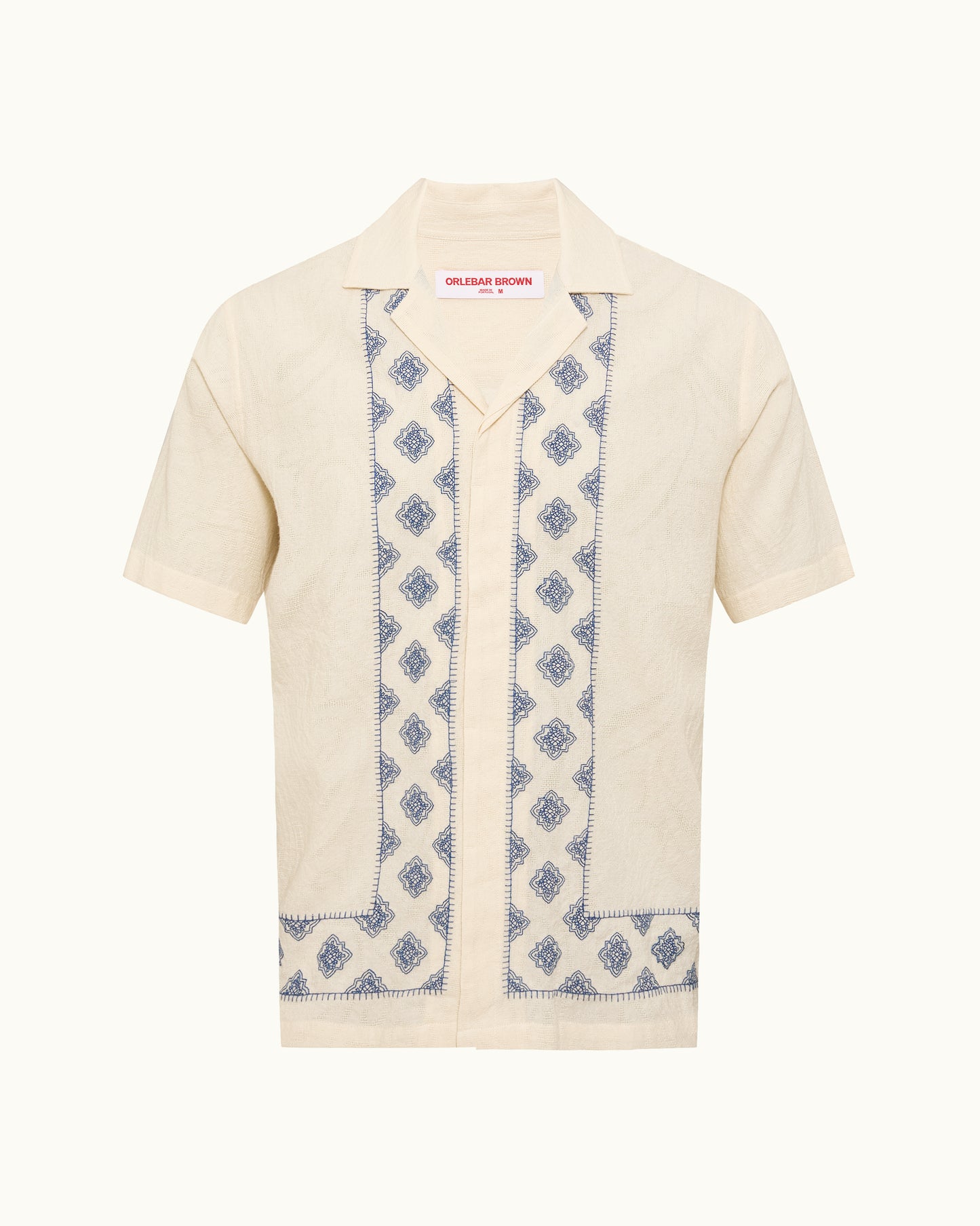 Short-sleeve cardigan with blue patterned trim on a white background