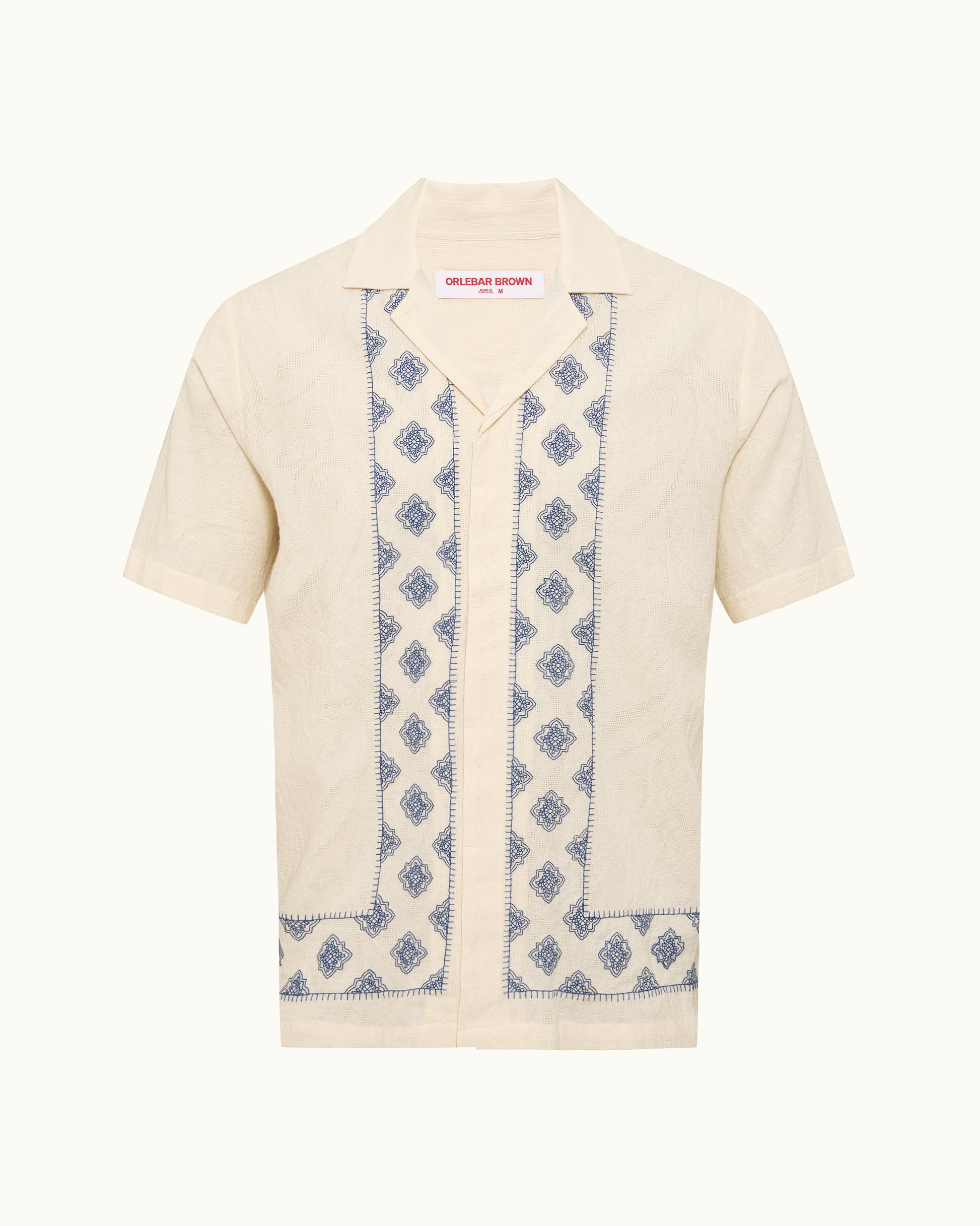 Short-sleeve cardigan with blue patterned trim on a white background