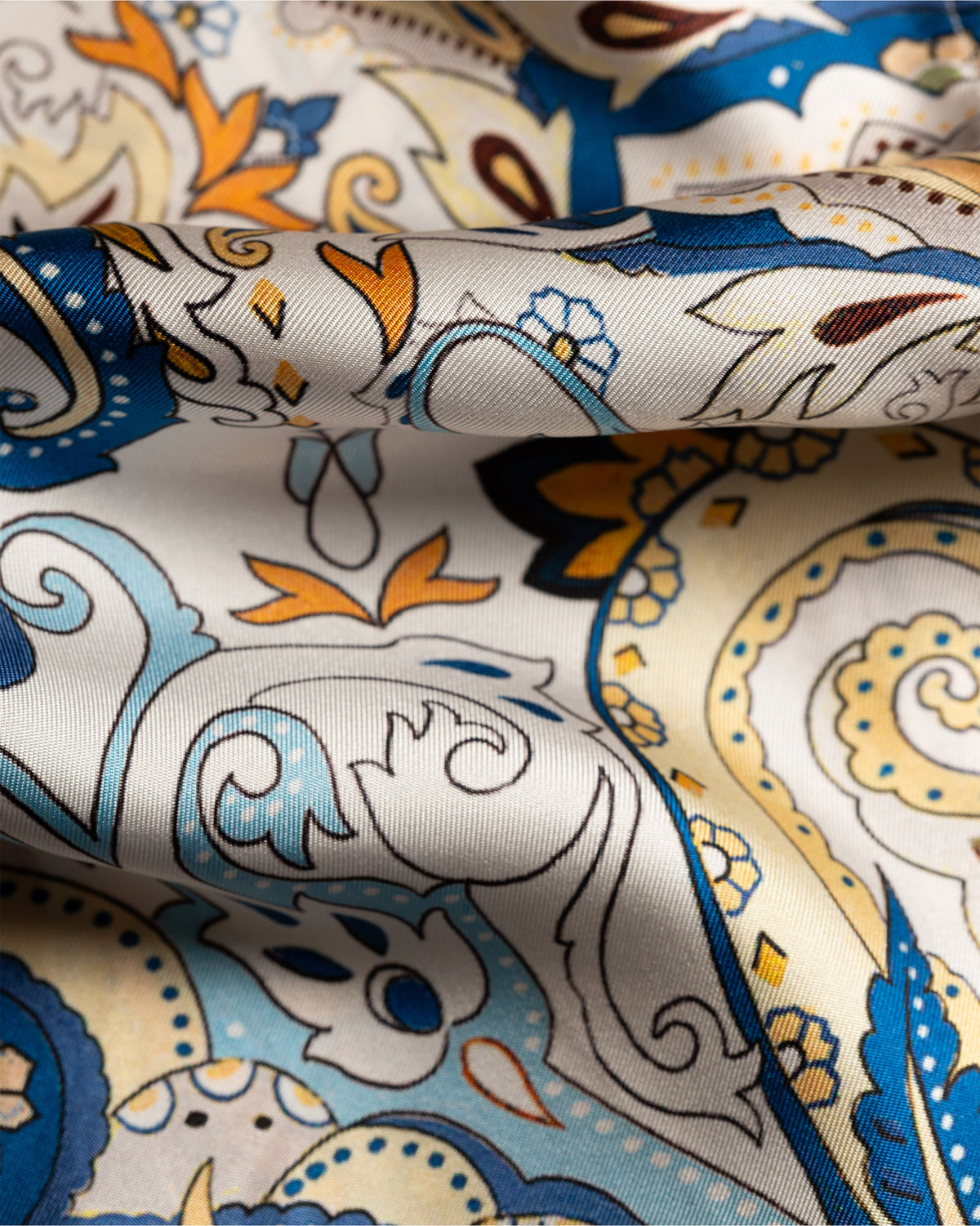 Close-up of patterned fabric with blue, orange, and beige colors.