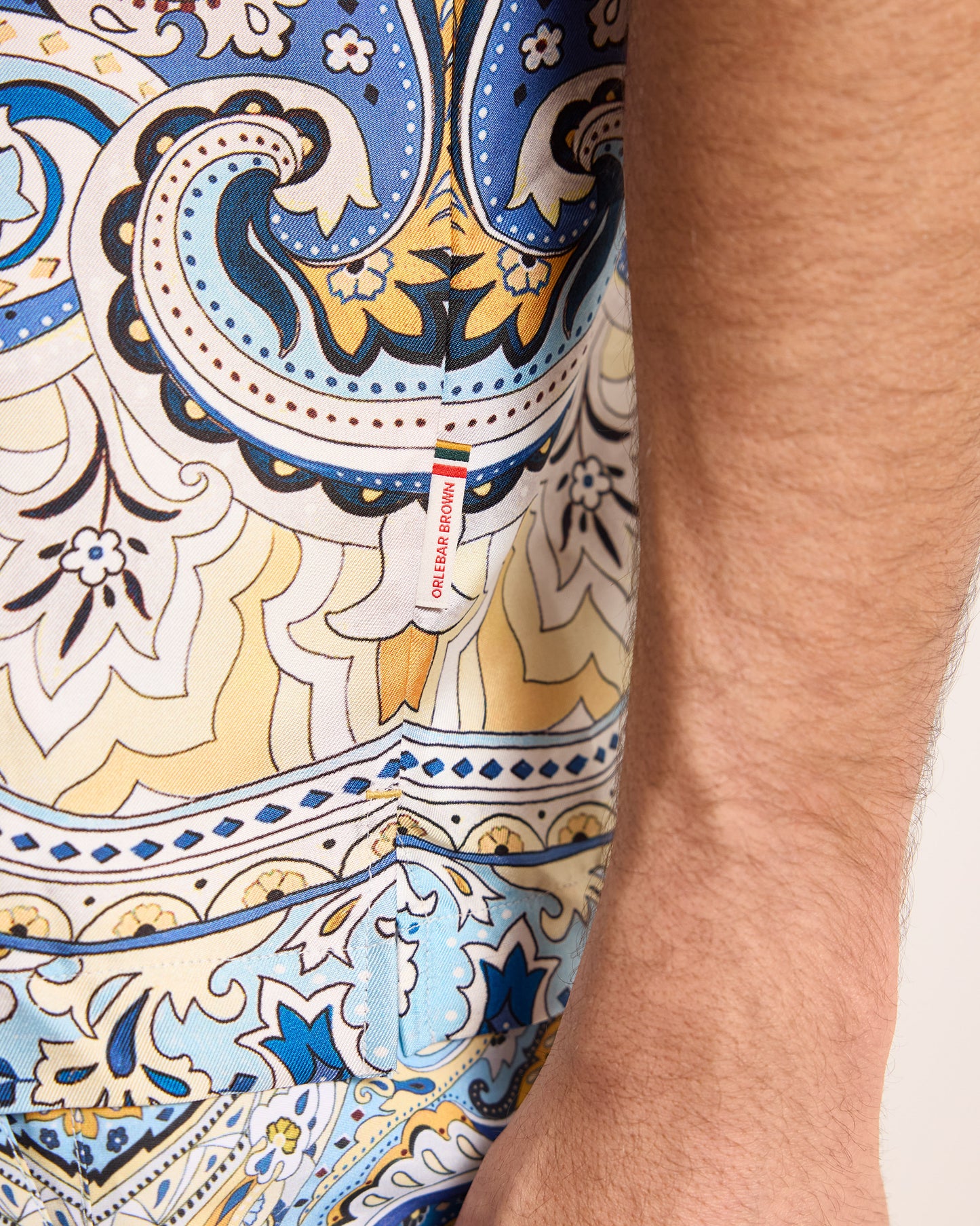 Close-up of a colorful patterned fabric with a brand label.