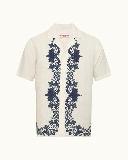 White shirt with blue floral embroidery on a white background