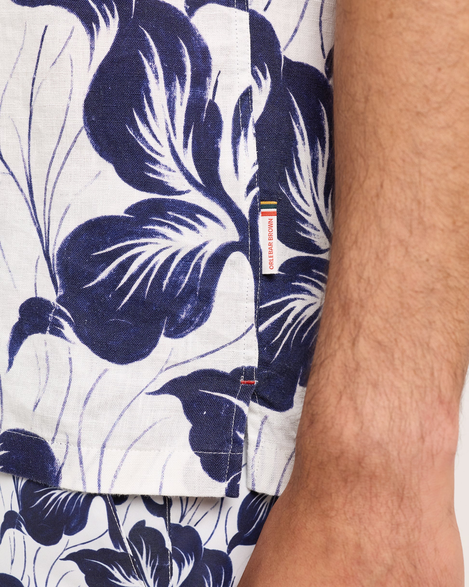Close-up of a navy floral patterned shirt with a brand label.