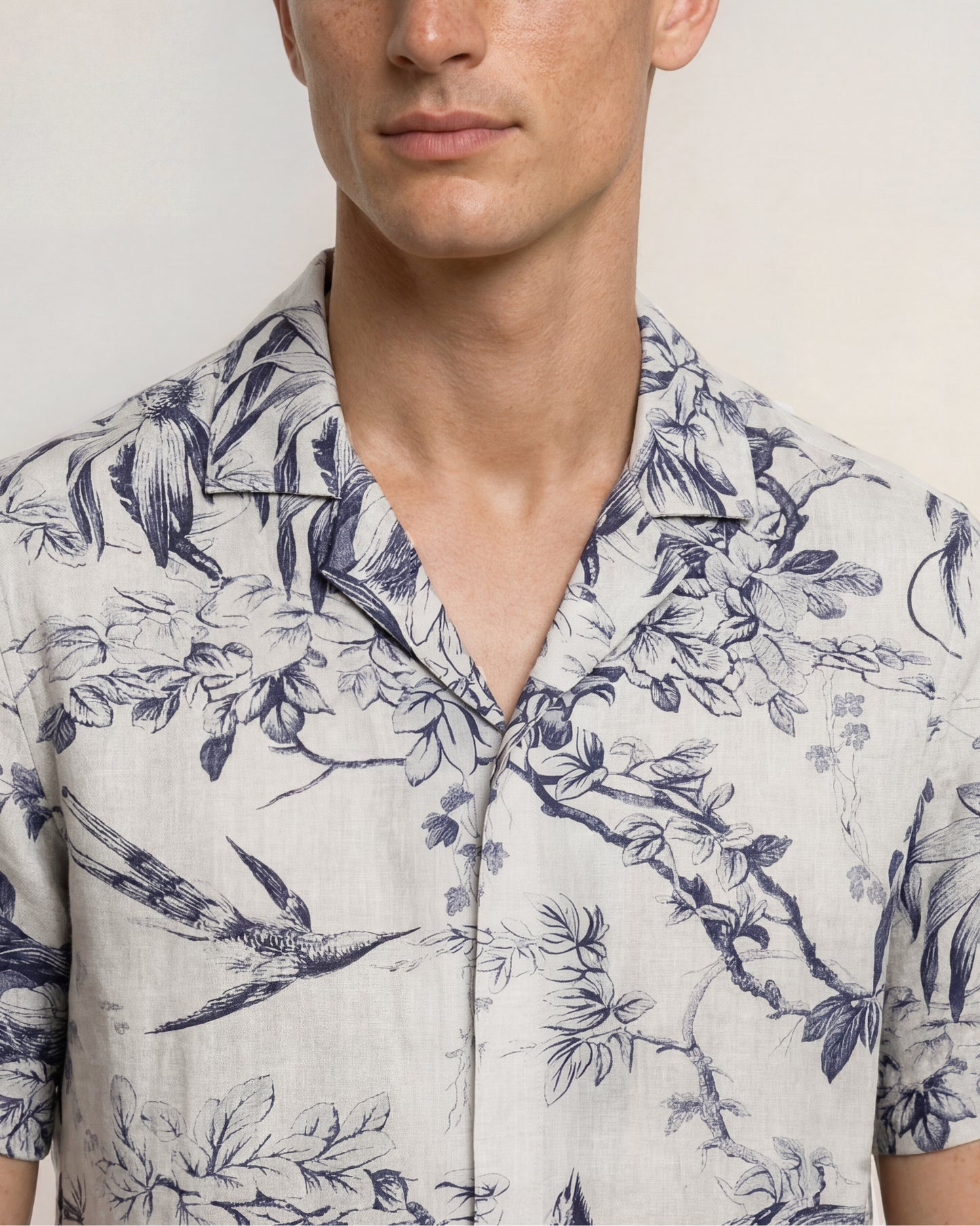 Man wearing a floral patterned shirt with blue and white design.
