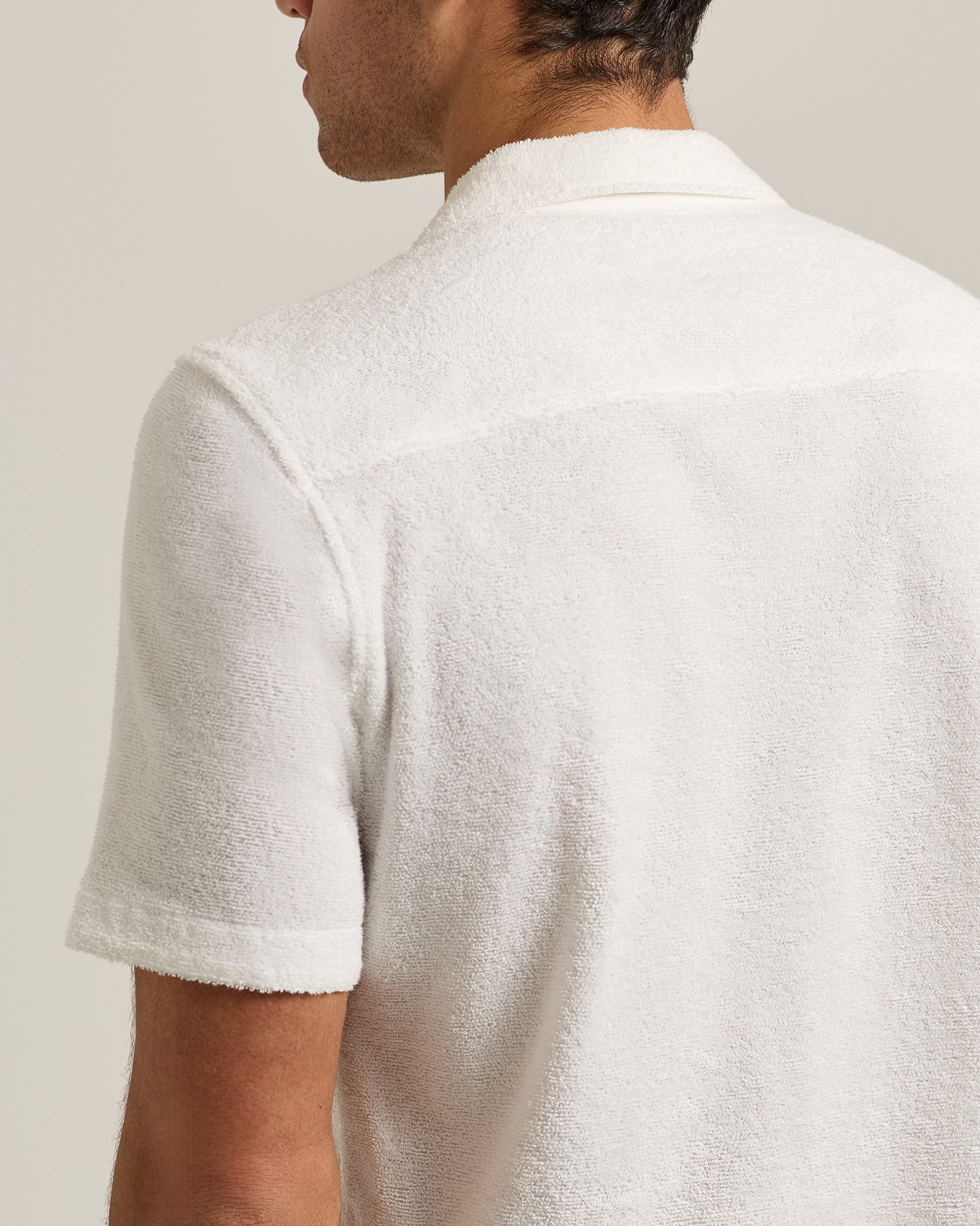 Man wearing a textured white shirt against a plain background
