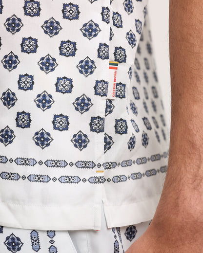 White shirt with blue geometric pattern worn by a person