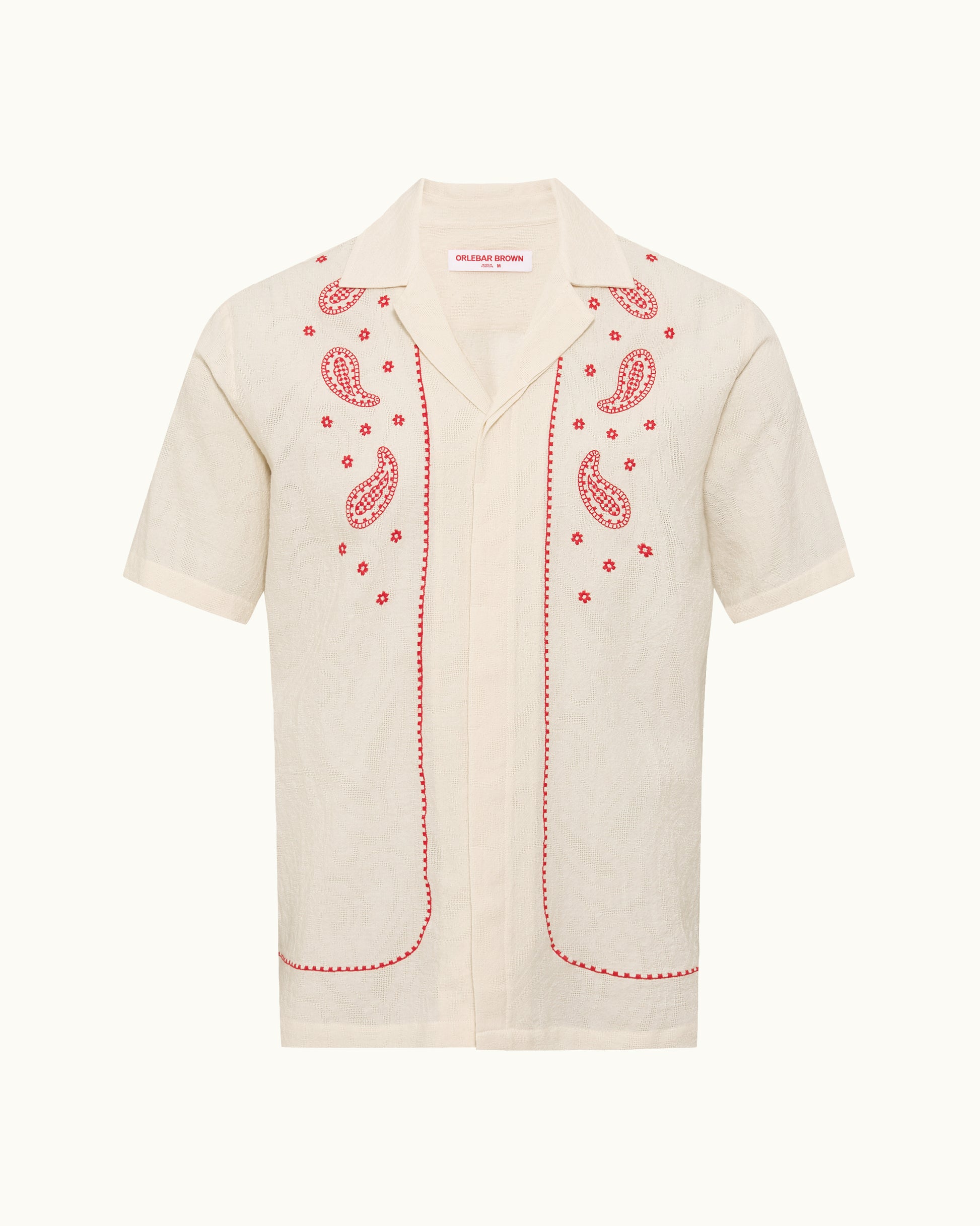 Beige shirt with red paisley patterns on a white background