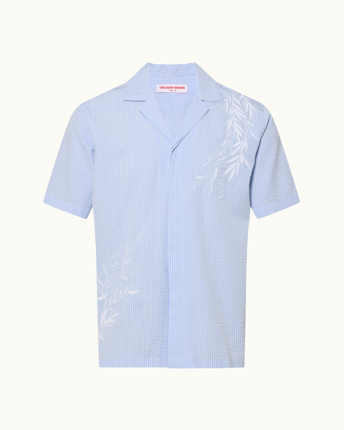 A blue striped seersucker shirt with a white embroidery detail on a plain background