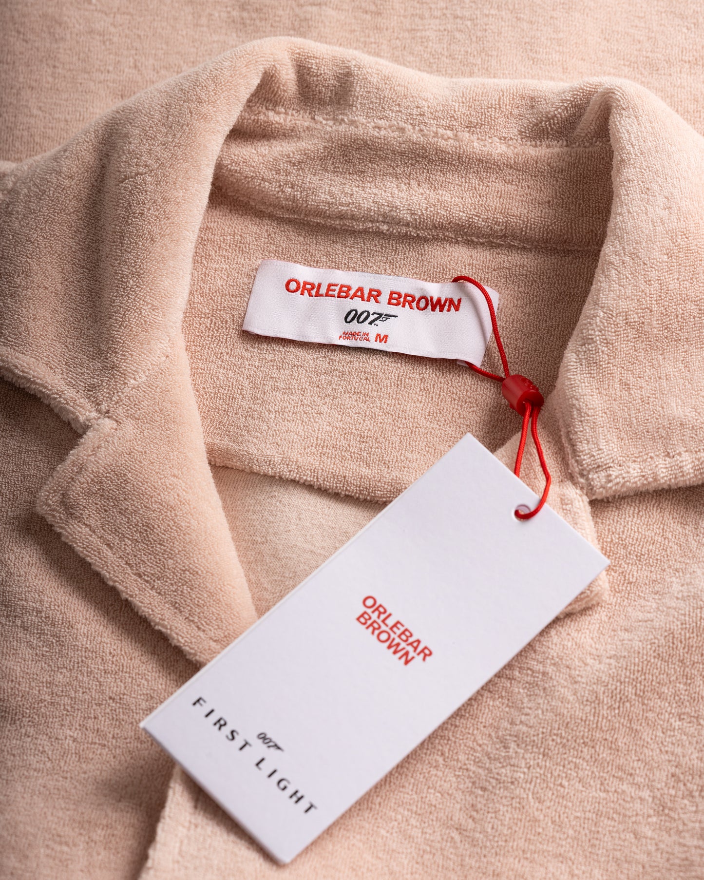 Close-up of a beige garment with 'Orlebar Brown' label and tag.