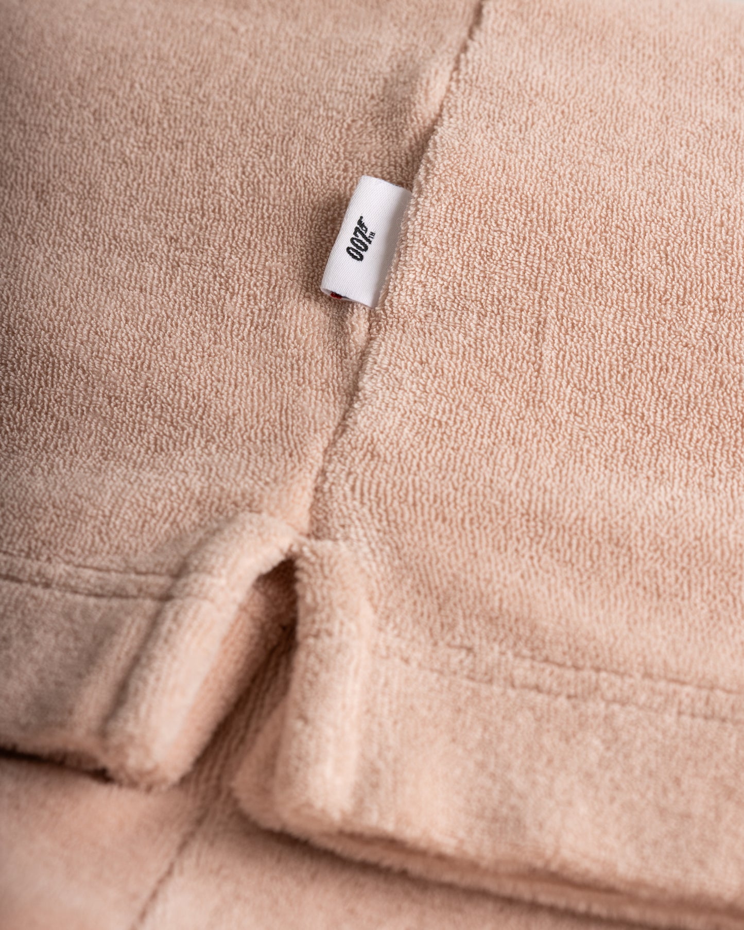 Close-up of a beige fabric with a brand label on a soft texture background