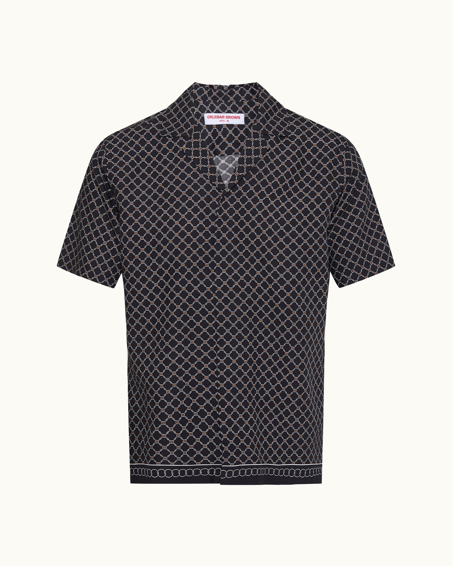 A short-sleeve button-up shirt with a black base and a white geometric lattice pattern, featuring a pointed collar and a decorative border on the hem, shown against a plain off-white background.