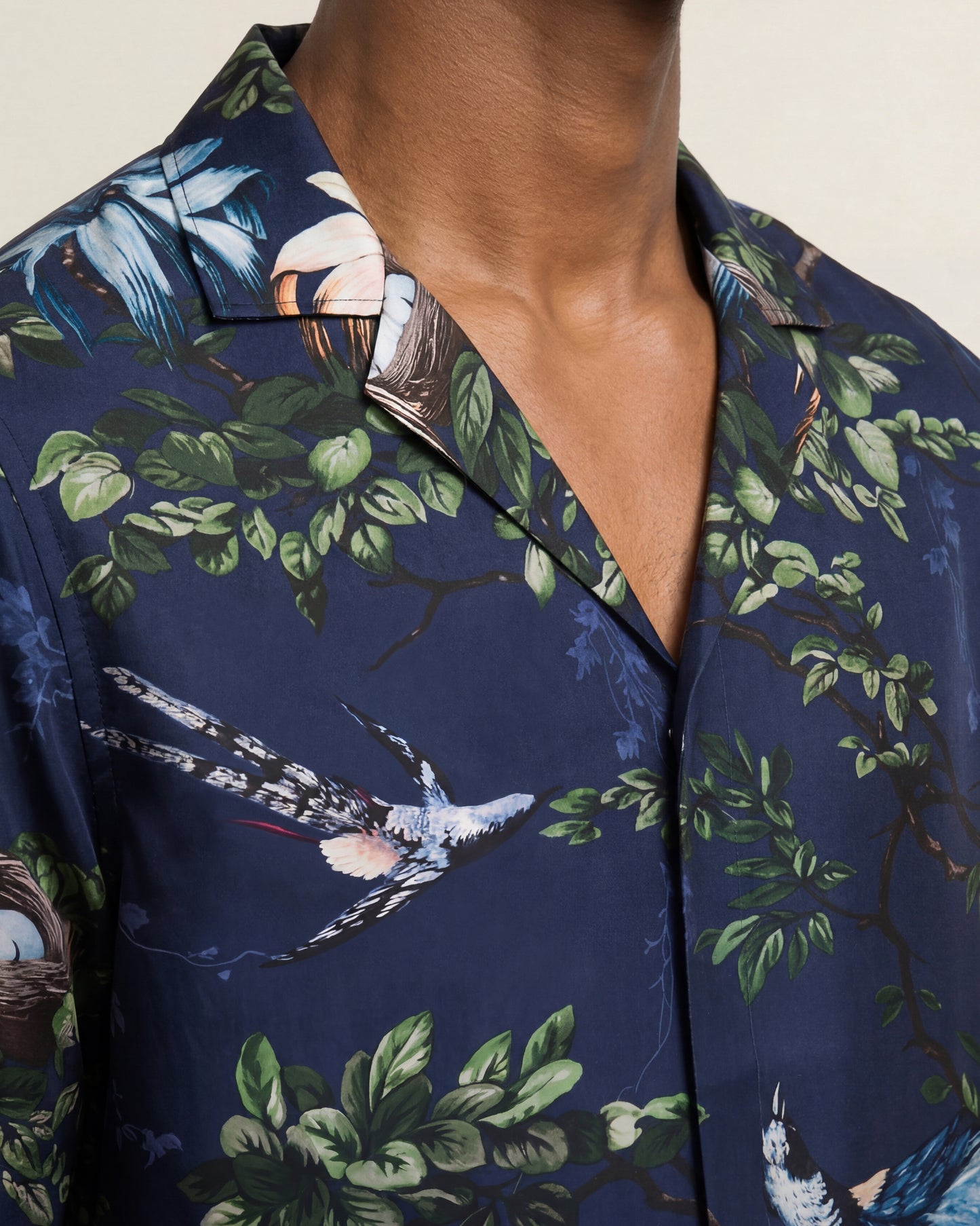 Navy blue shirt with nature-themed print featuring birds and foliage.