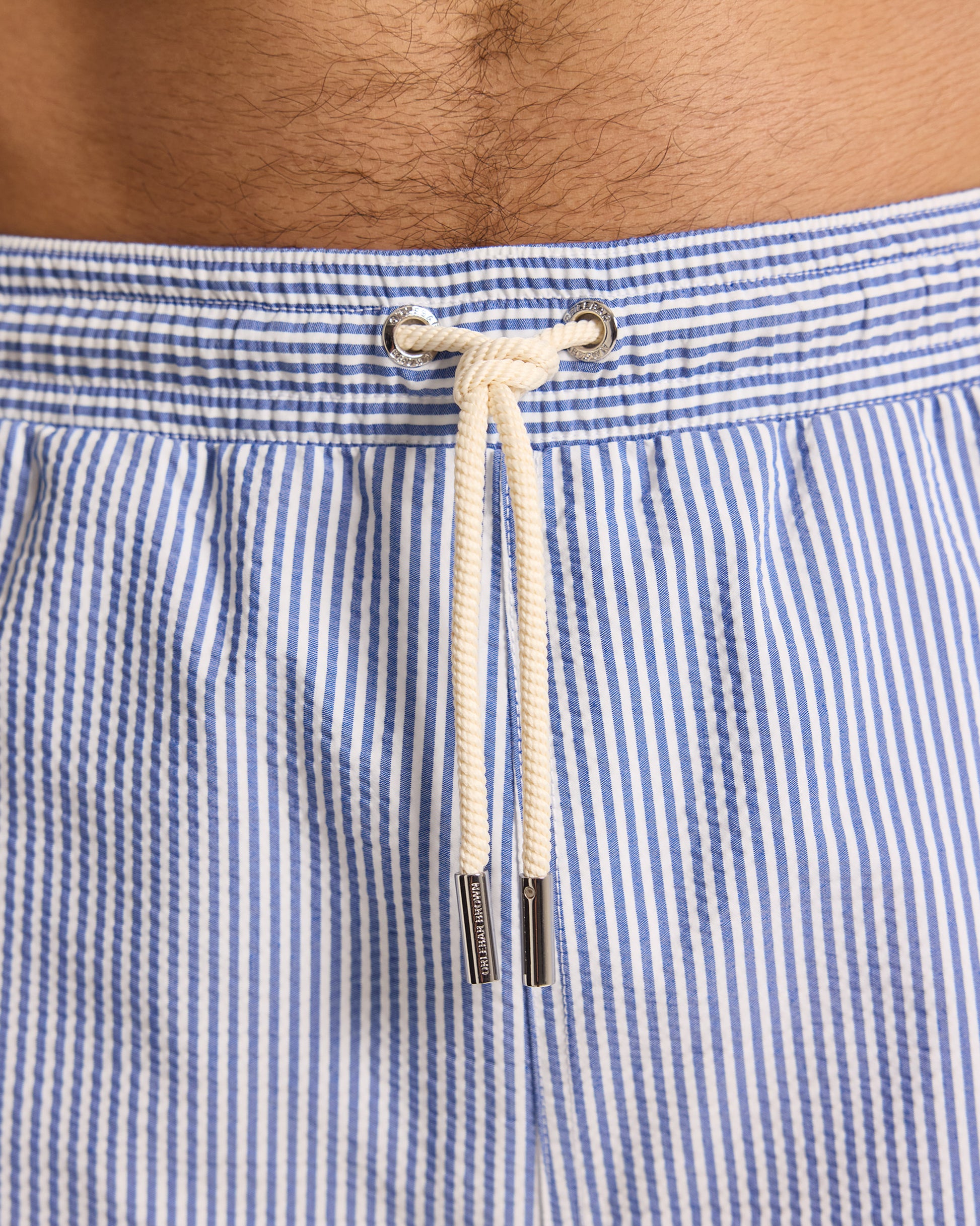Close-up of blue and white striped swim shorts with a drawstring.