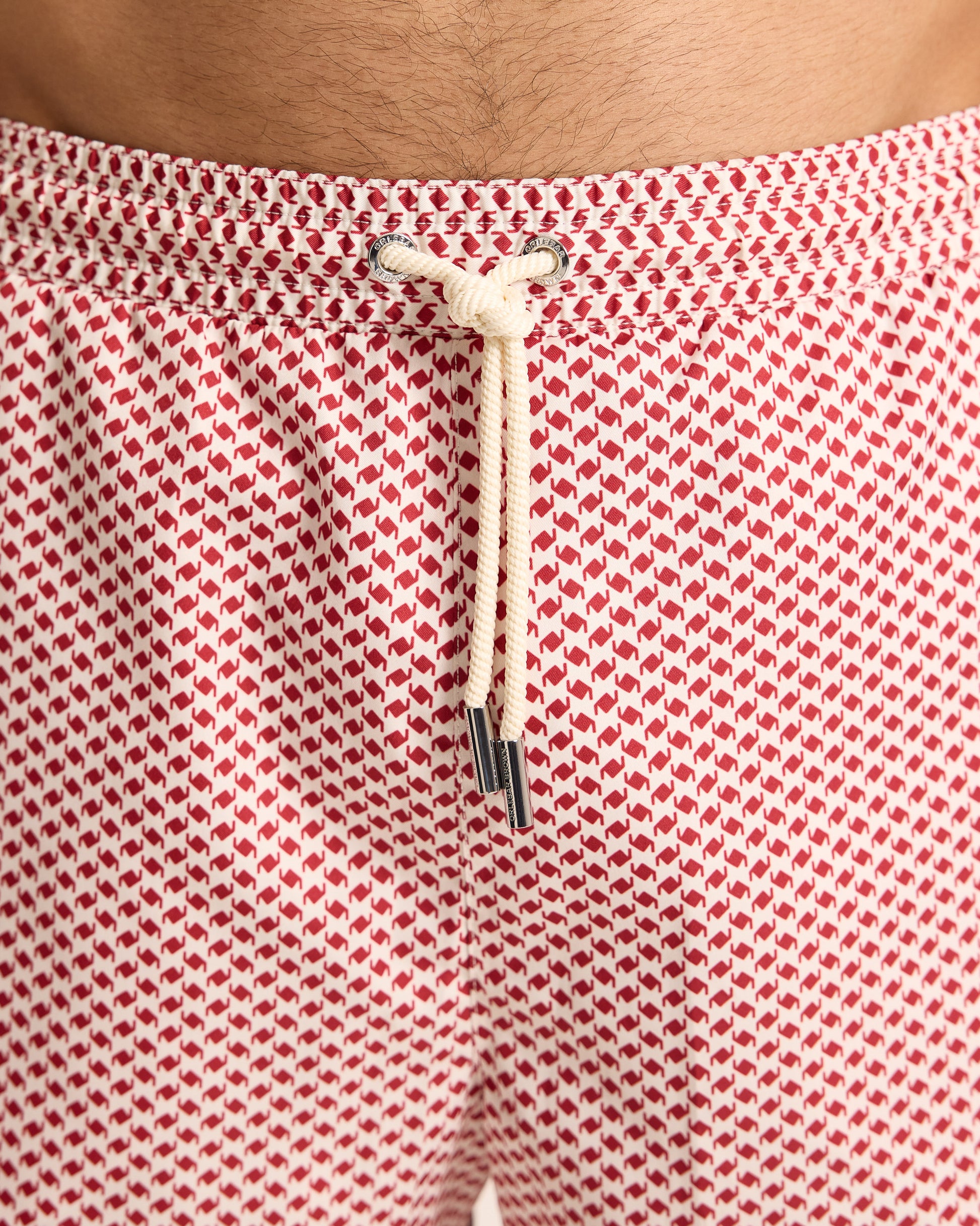 Red and white patterned shorts with a drawstring on a plain background
