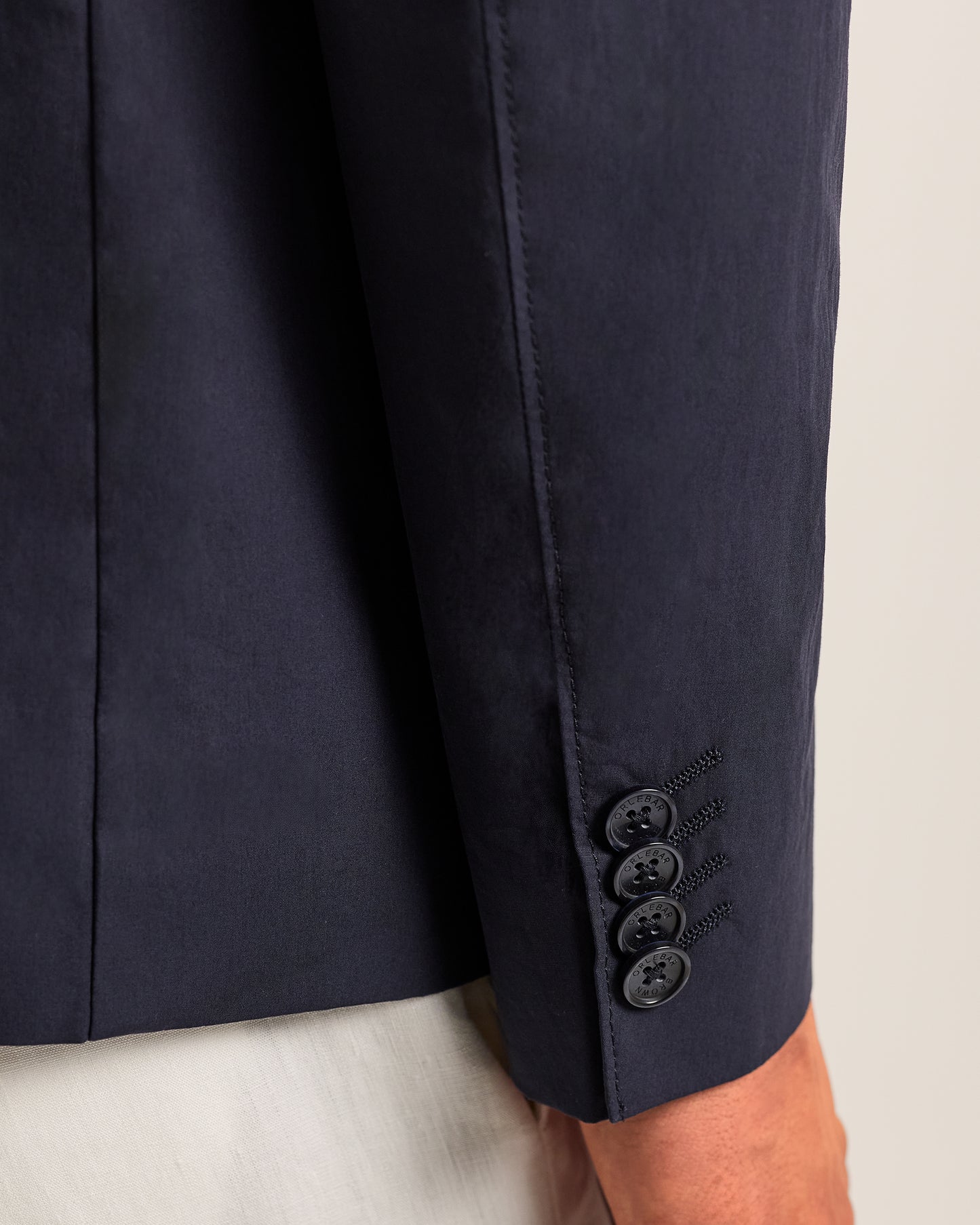 Navy blue suit jacket with button details on a light background