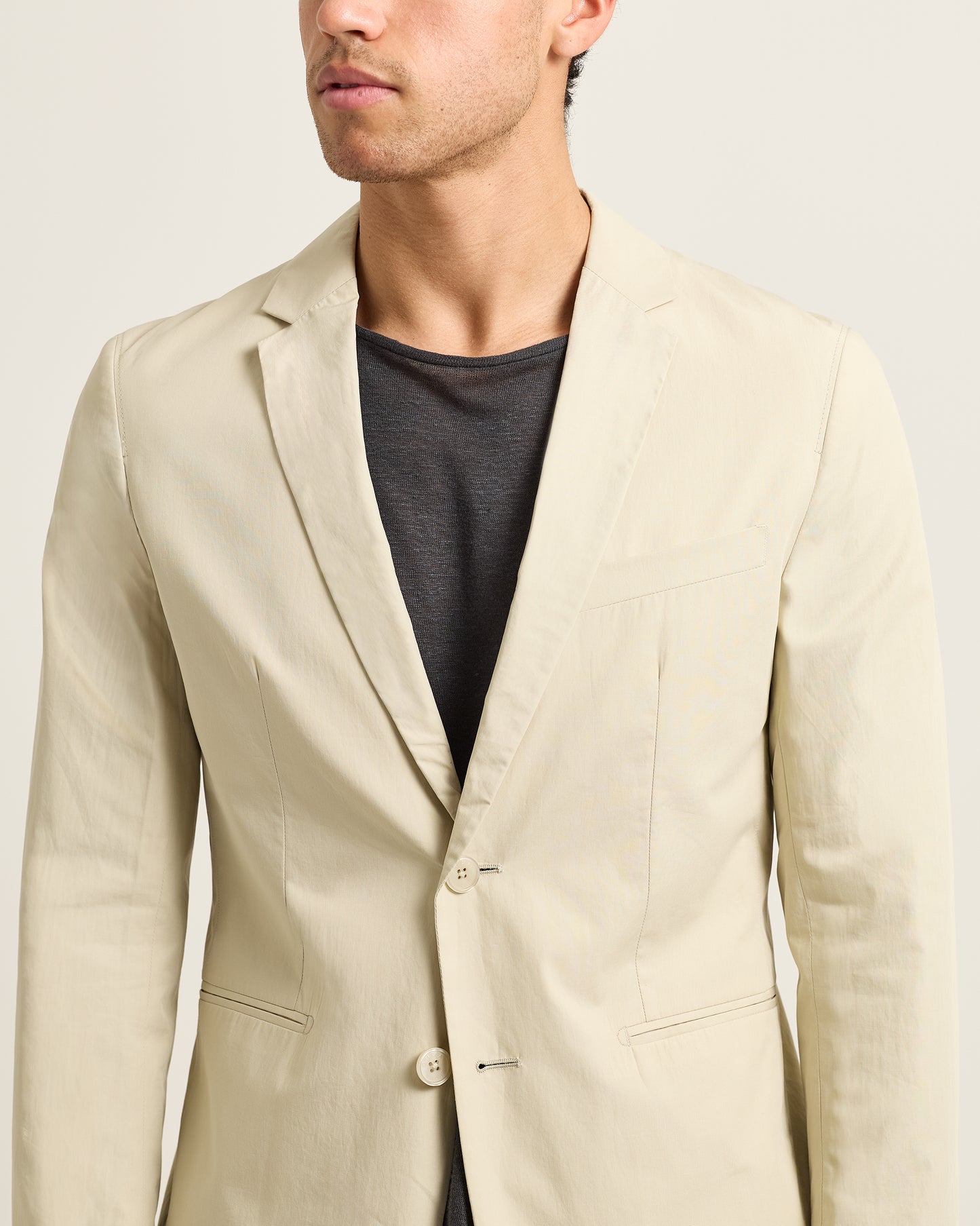 Beige blazer worn by a person on a plain background