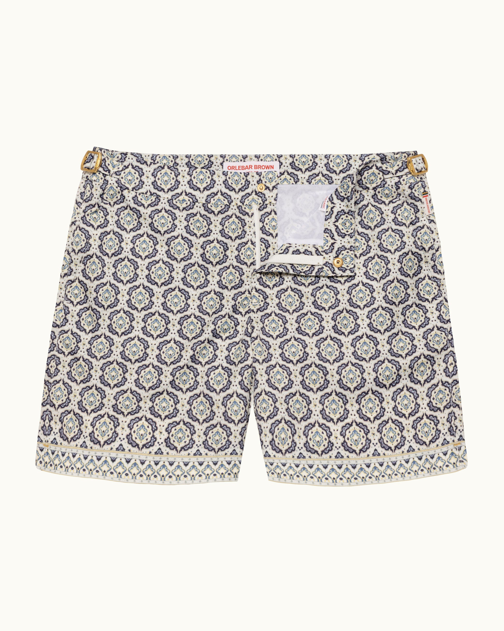 Printed beige swim shorts on a plain background