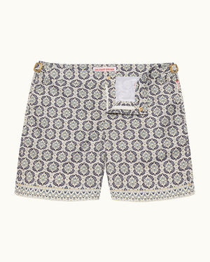Printed beige swim shorts on a plain background