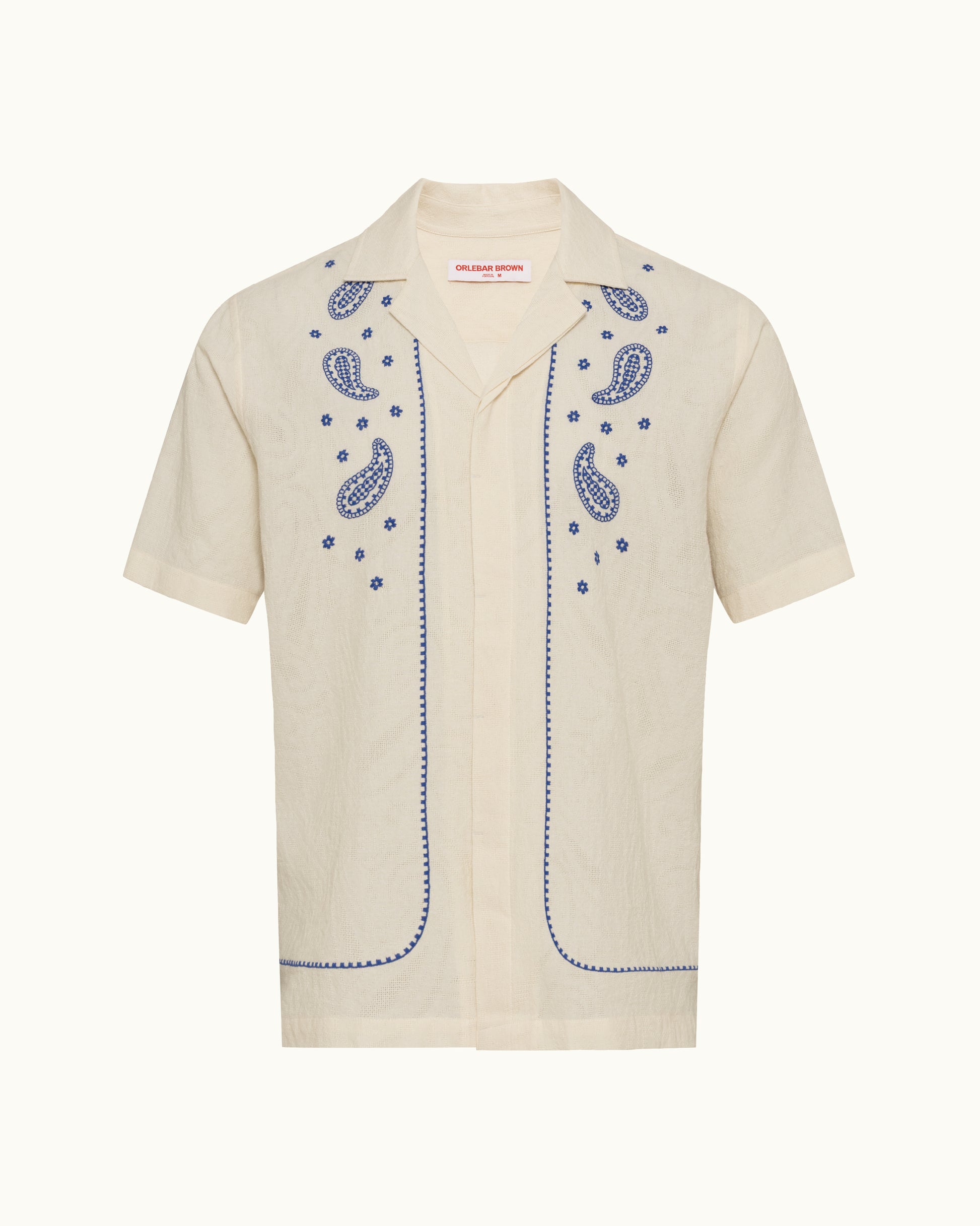 Beige shirt with blue embroidery on a white background