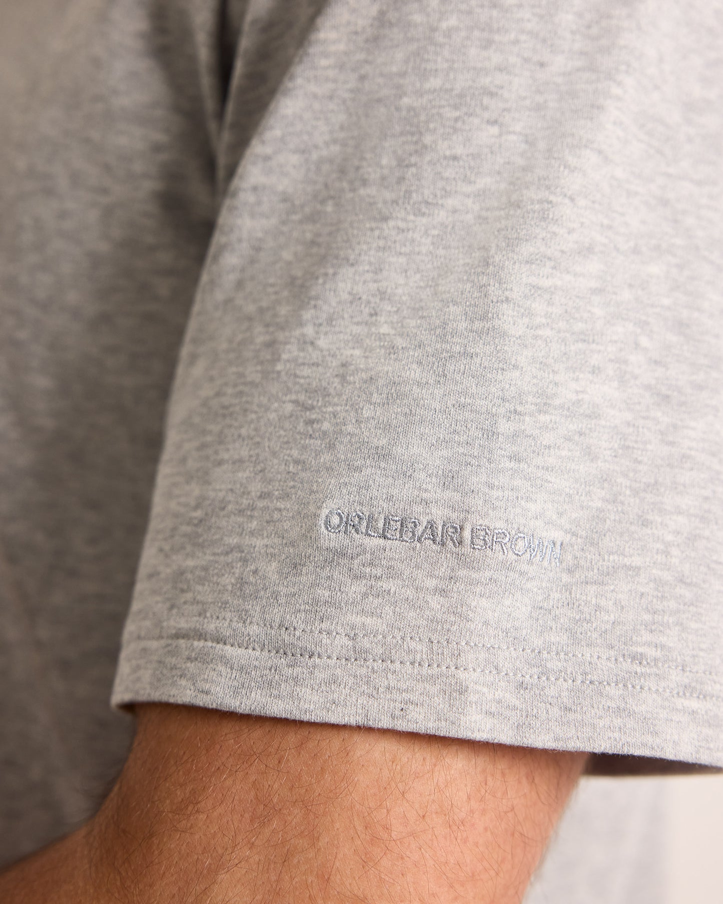 Gray t-shirt with a brand logo on the sleeve