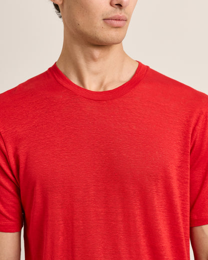 Person wearing a red t-shirt against a neutral background