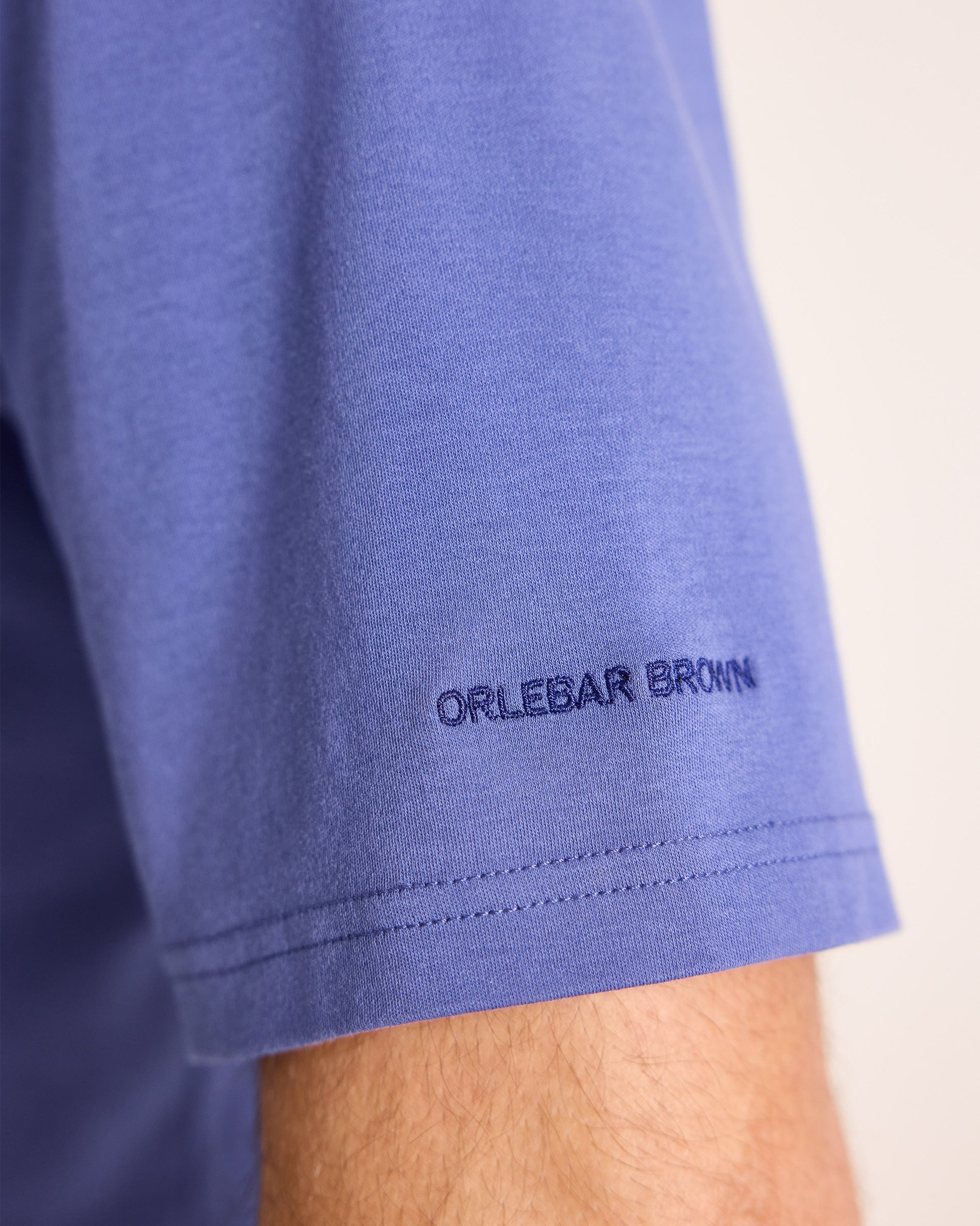 Close-up of a blue garment with 'Orlebar Brown' branding on a light background