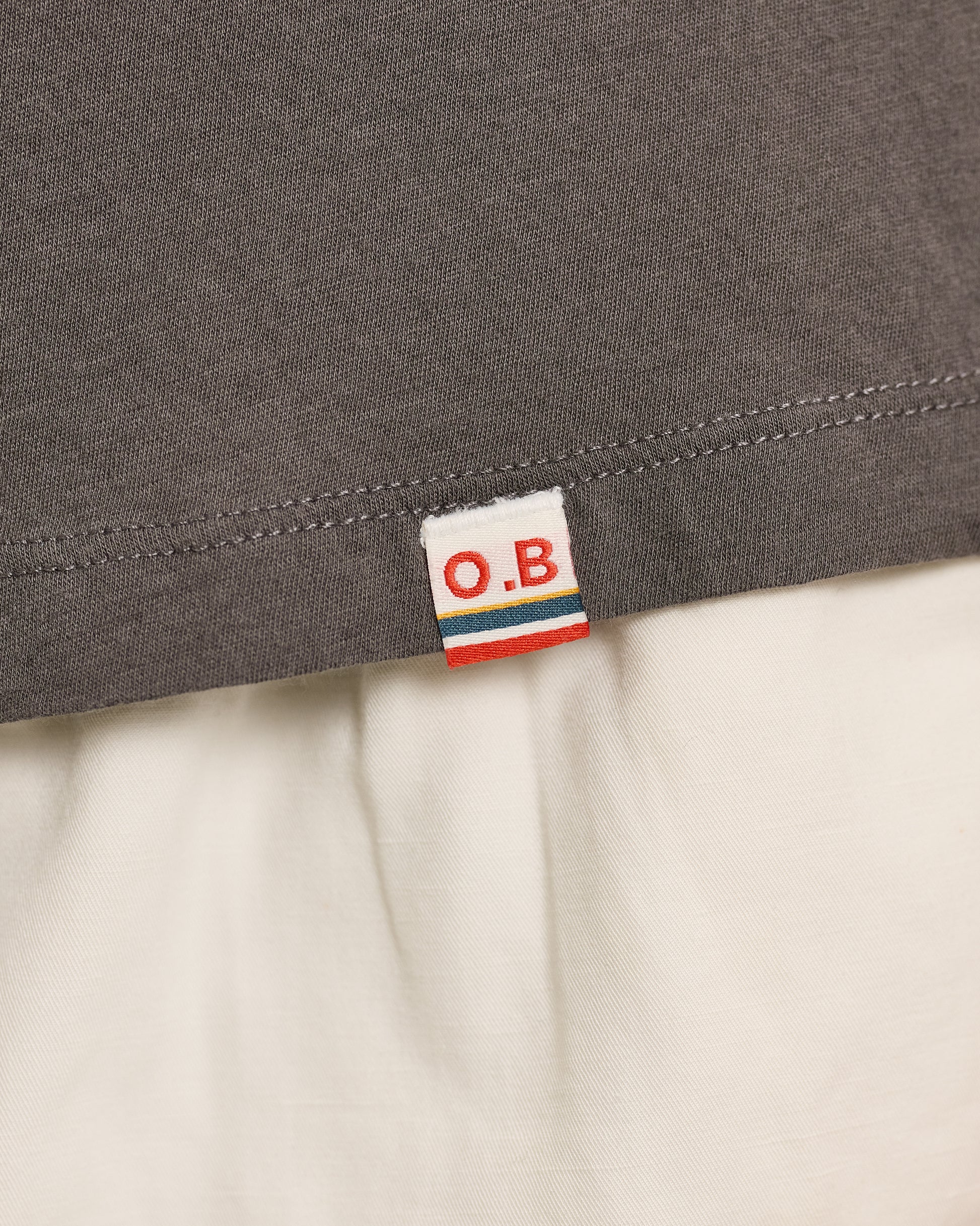 Close-up of a gray fabric with an O.B. label on a beige background
