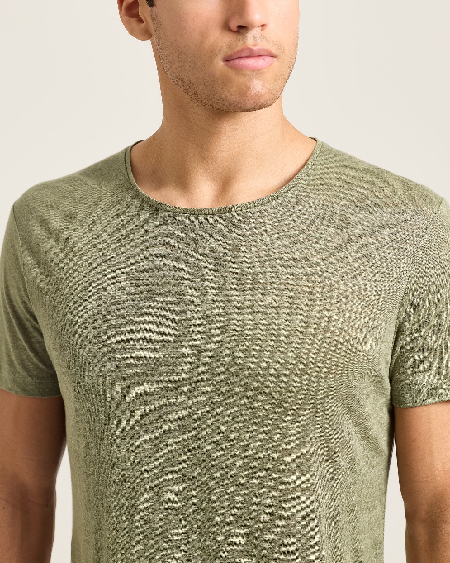 Man wearing a green t-shirt against a plain background