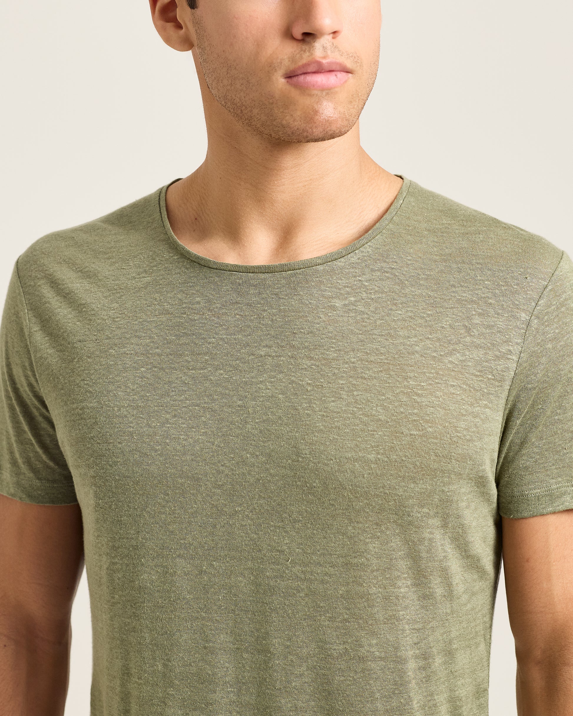 Man wearing a green t-shirt against a plain background