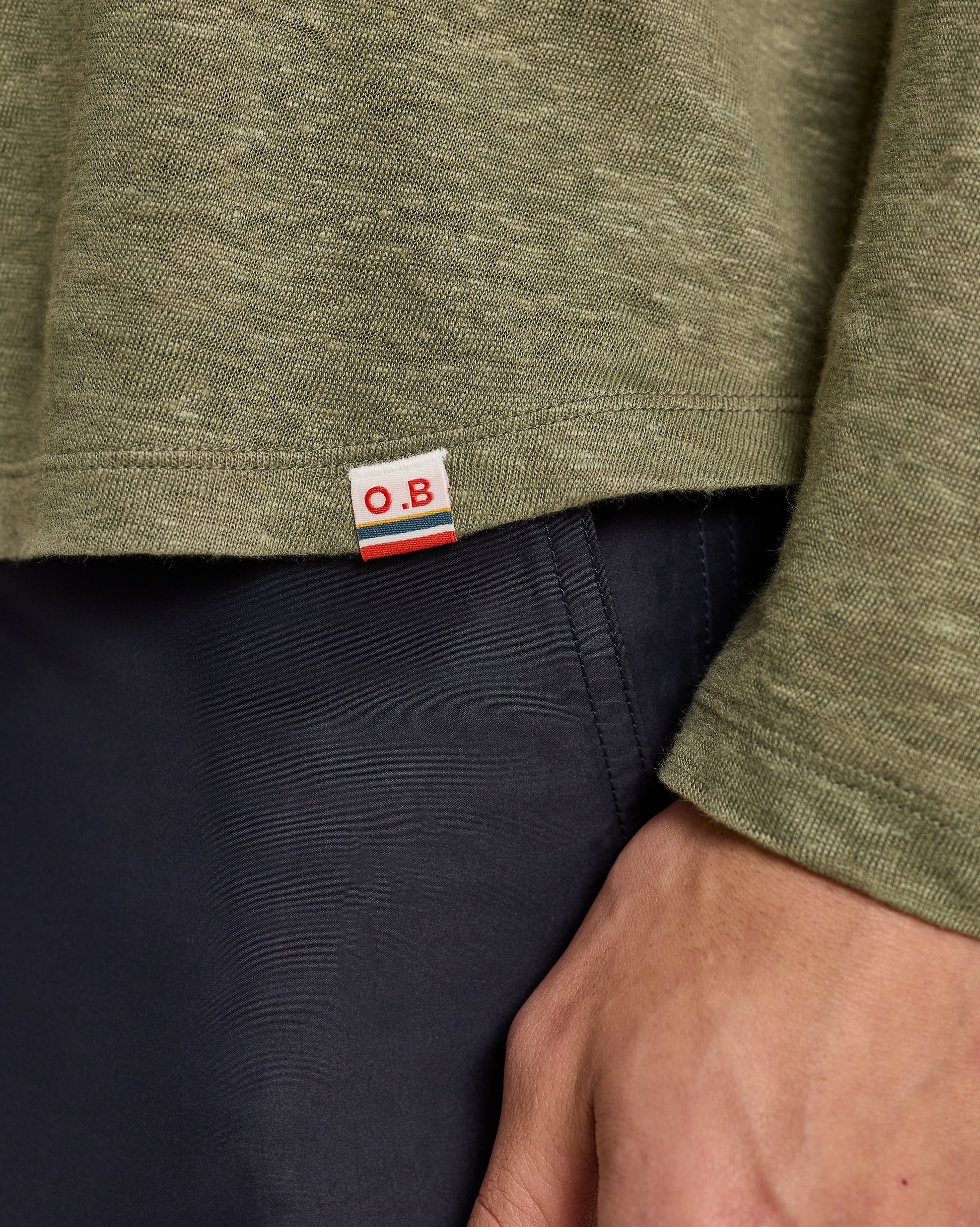 Close-up of a green shirt with a brand label on a navy background