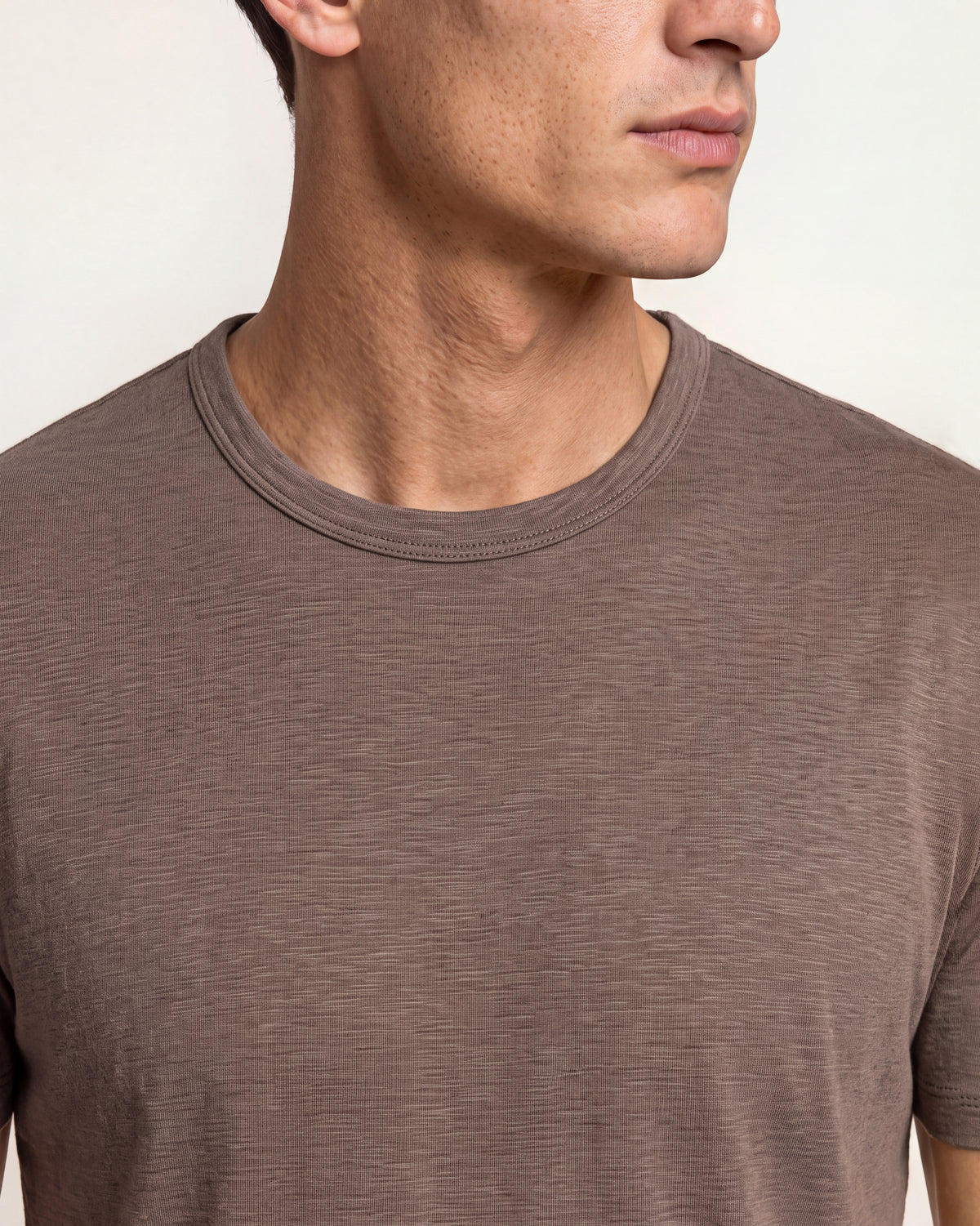 Man wearing brown t-shirt on a plain background