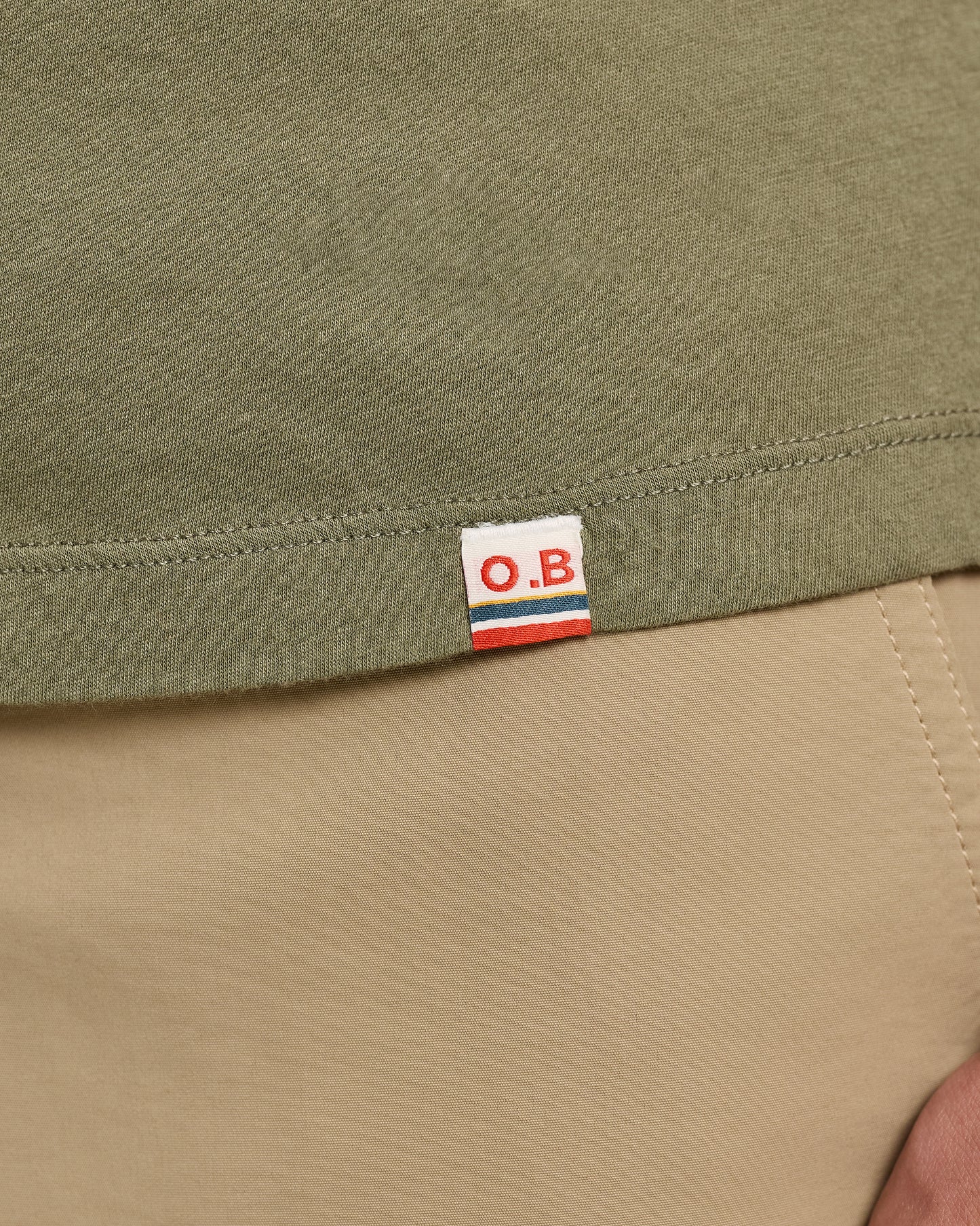 Close-up of a green fabric with an O.B. label on a beige background