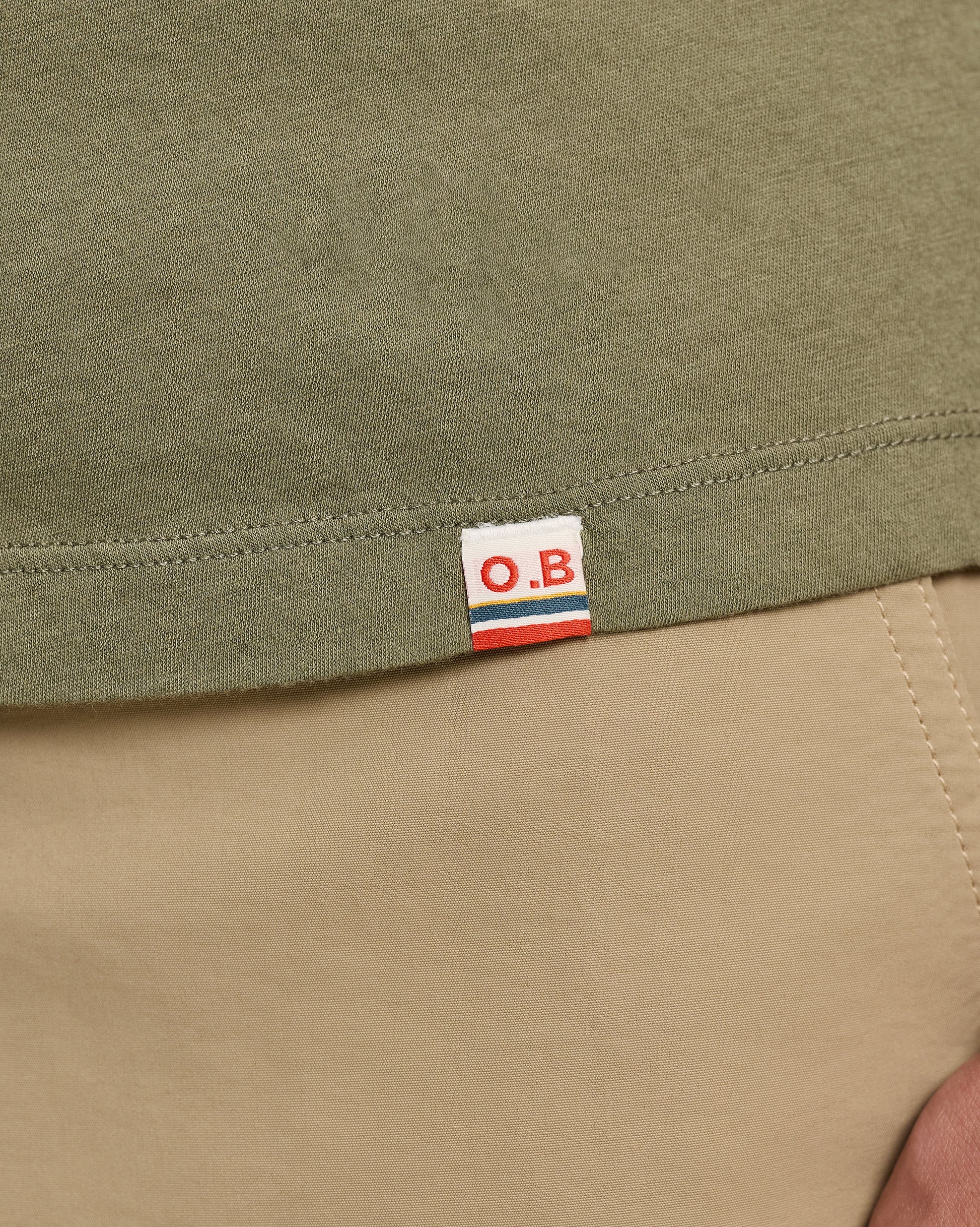 Close-up of a green fabric with an O.B. label on a beige background
