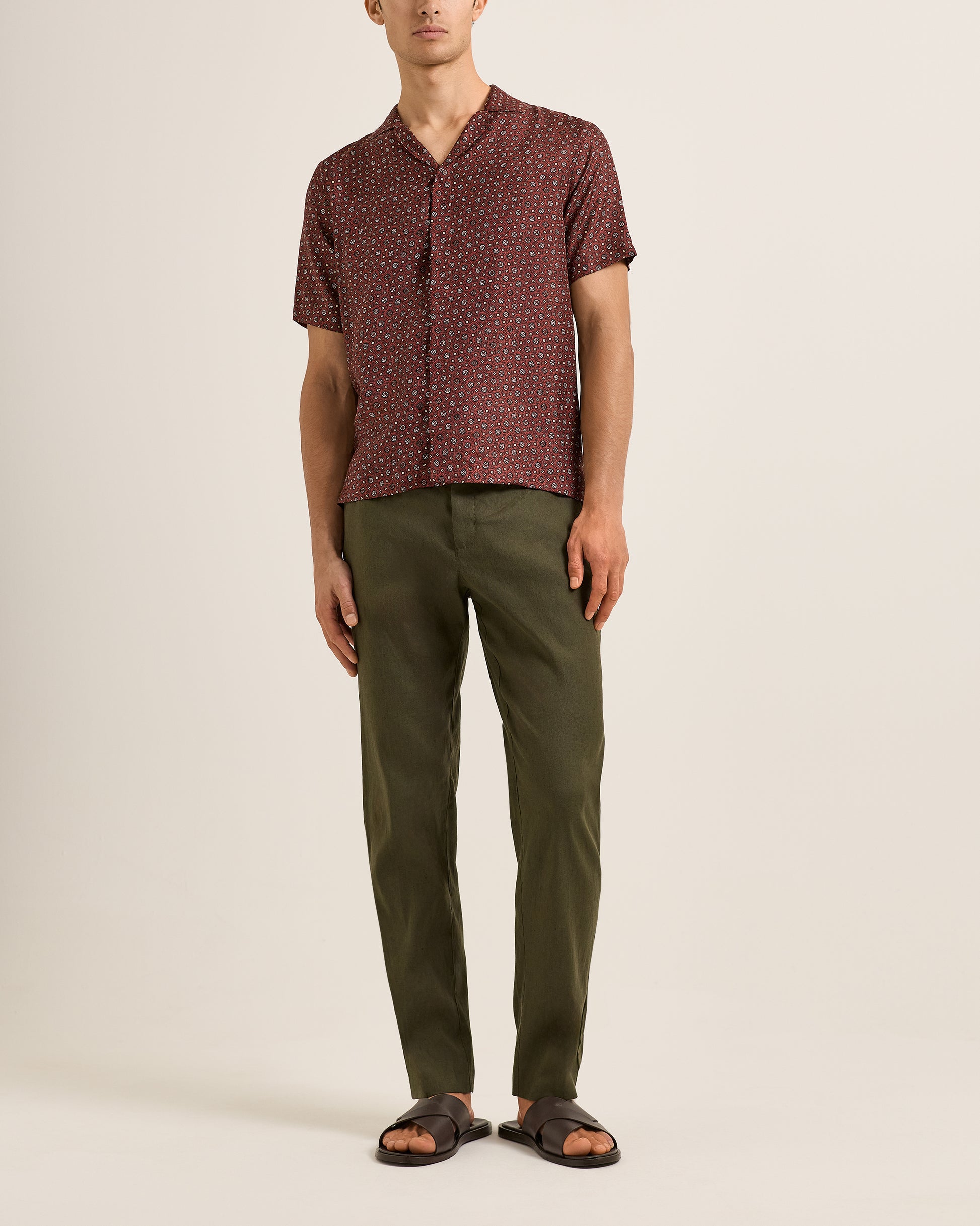 Man wearing a patterned shirt and Ray linen green pants on a beige background