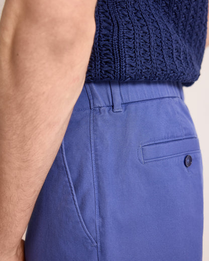 Person wearing blue pants with a textured blue top on a neutral background