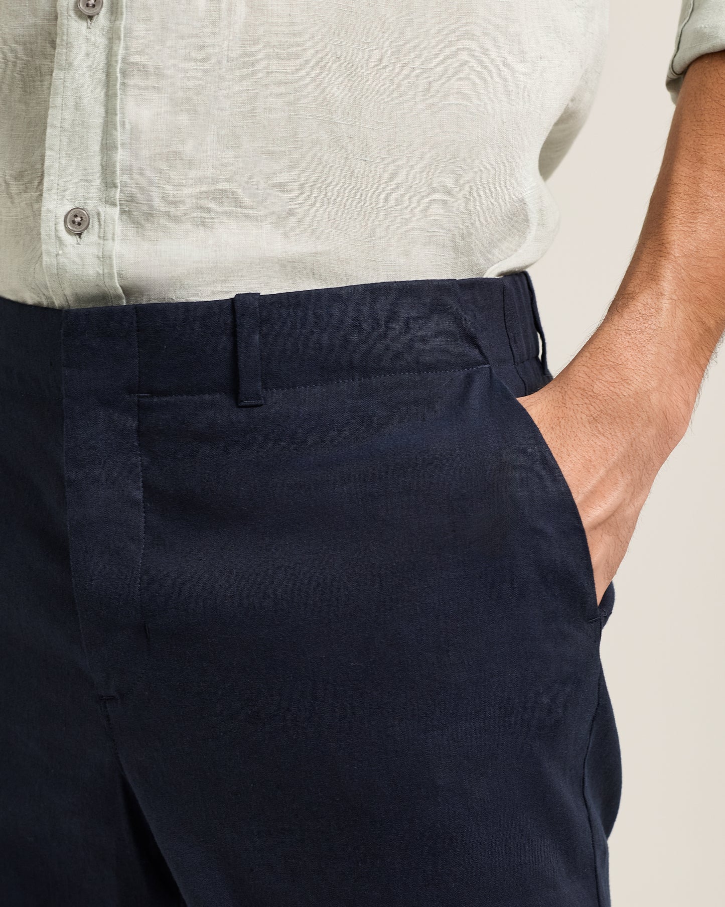 Ray linen navy tailored trousers worn by a person with a light-colored shirt in the background