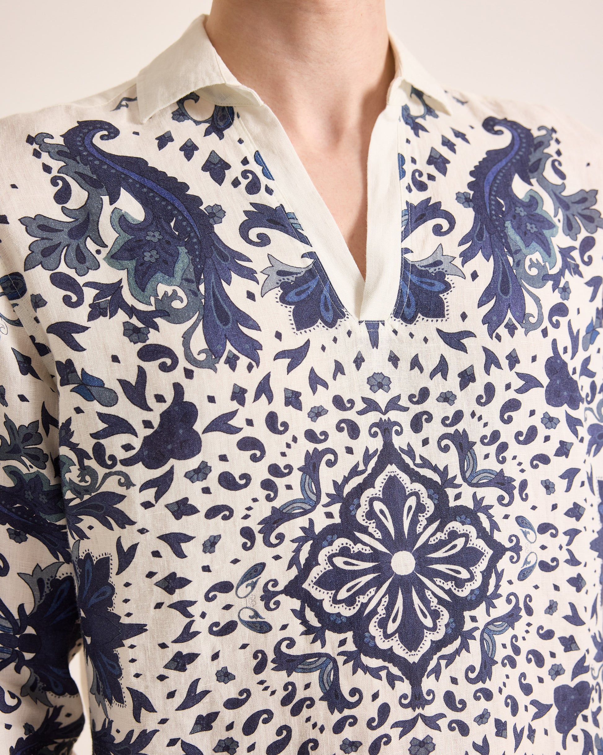 Close-up of a person wearing a white shirt with blue intricate patterns
