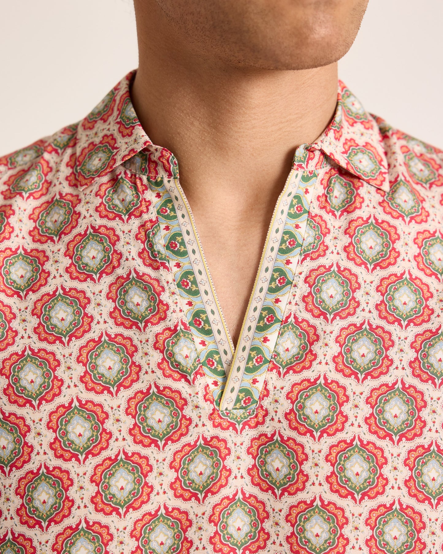 Person wearing a patterned shirt with a white background