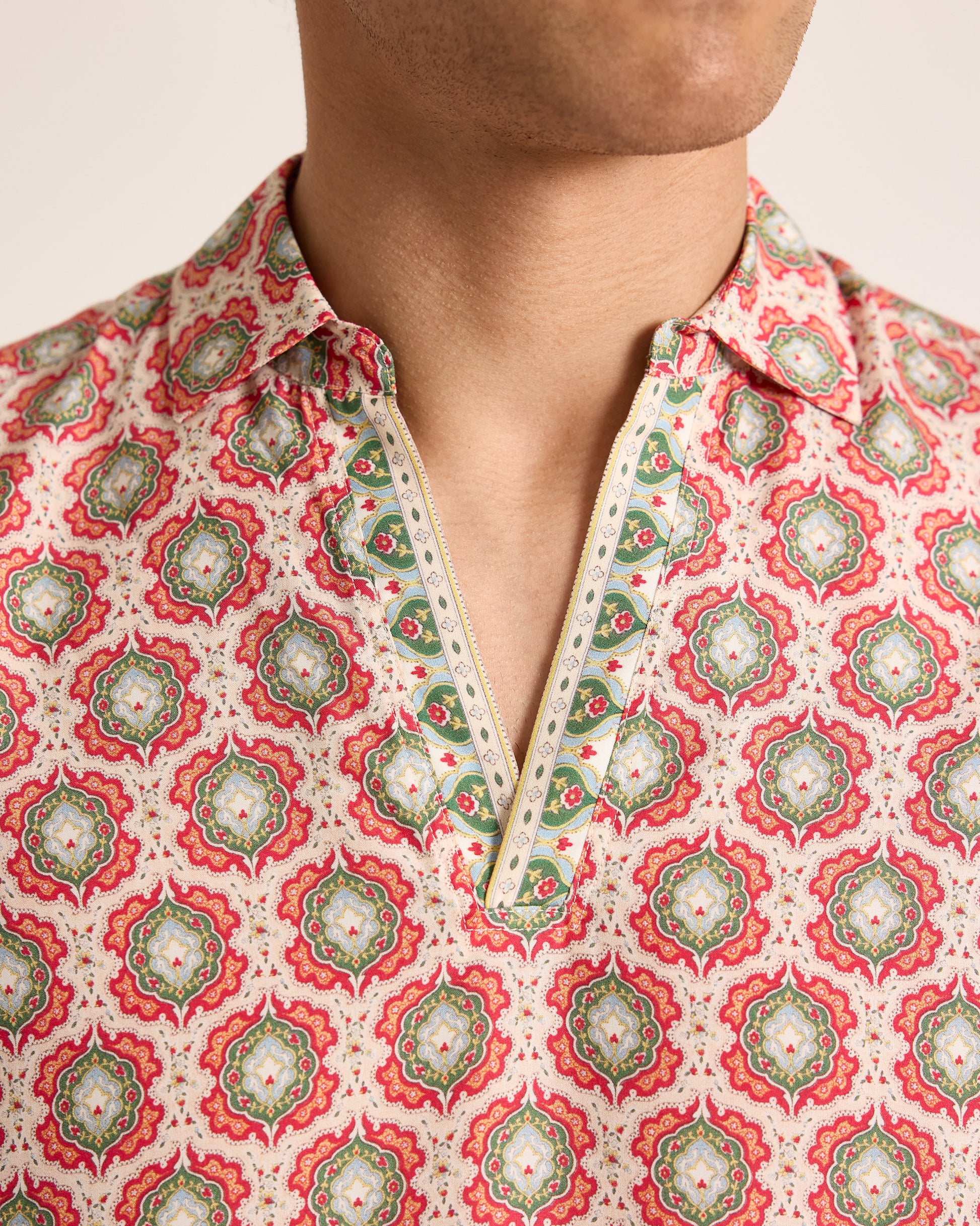 Person wearing a patterned shirt with a white background