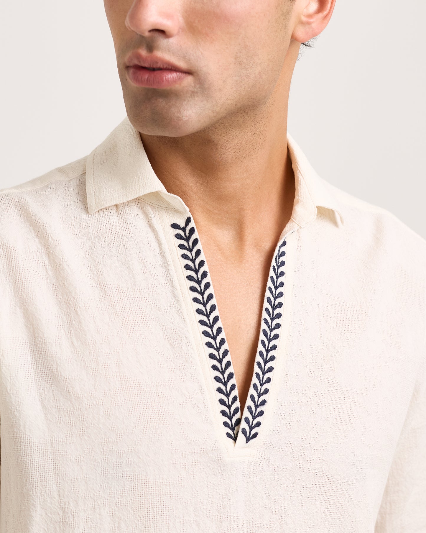 Close-up of White shirt with embroidered design on a white background