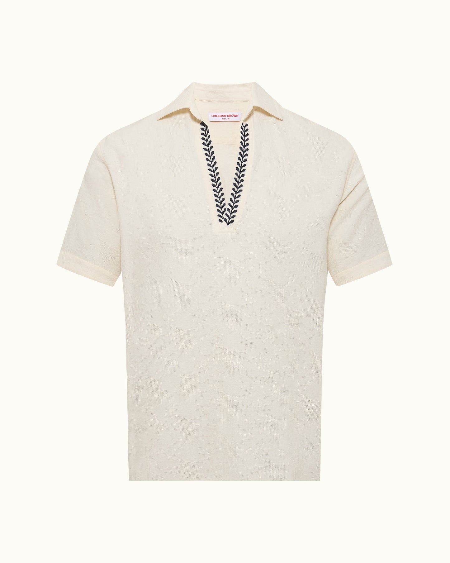 White polo shirt with embroidered design on a white background
