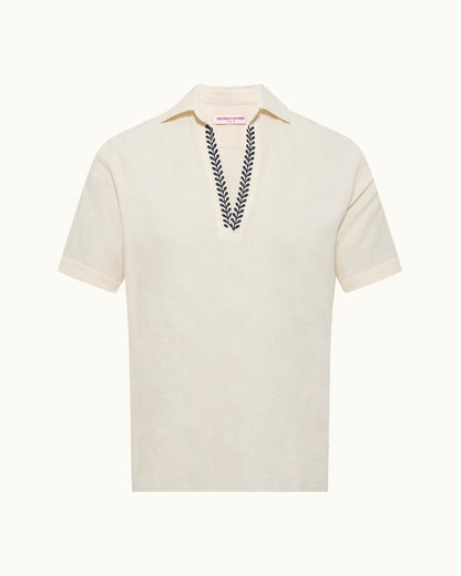 White polo shirt with embroidered design on a white background