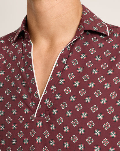 Close-up of a maroon shirt with a geometric pattern on a neutral background